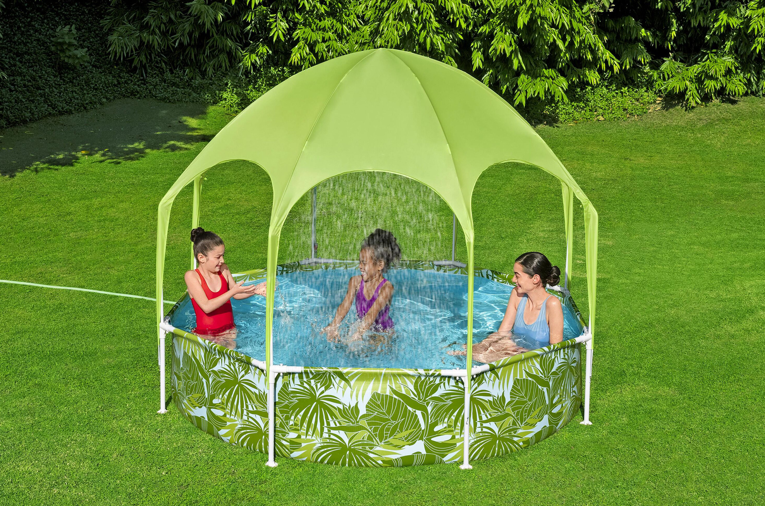 Tre persone, due bambini e un adulto, giocano in una piscina all'aperto con una tettoia verde in una giornata di sole.