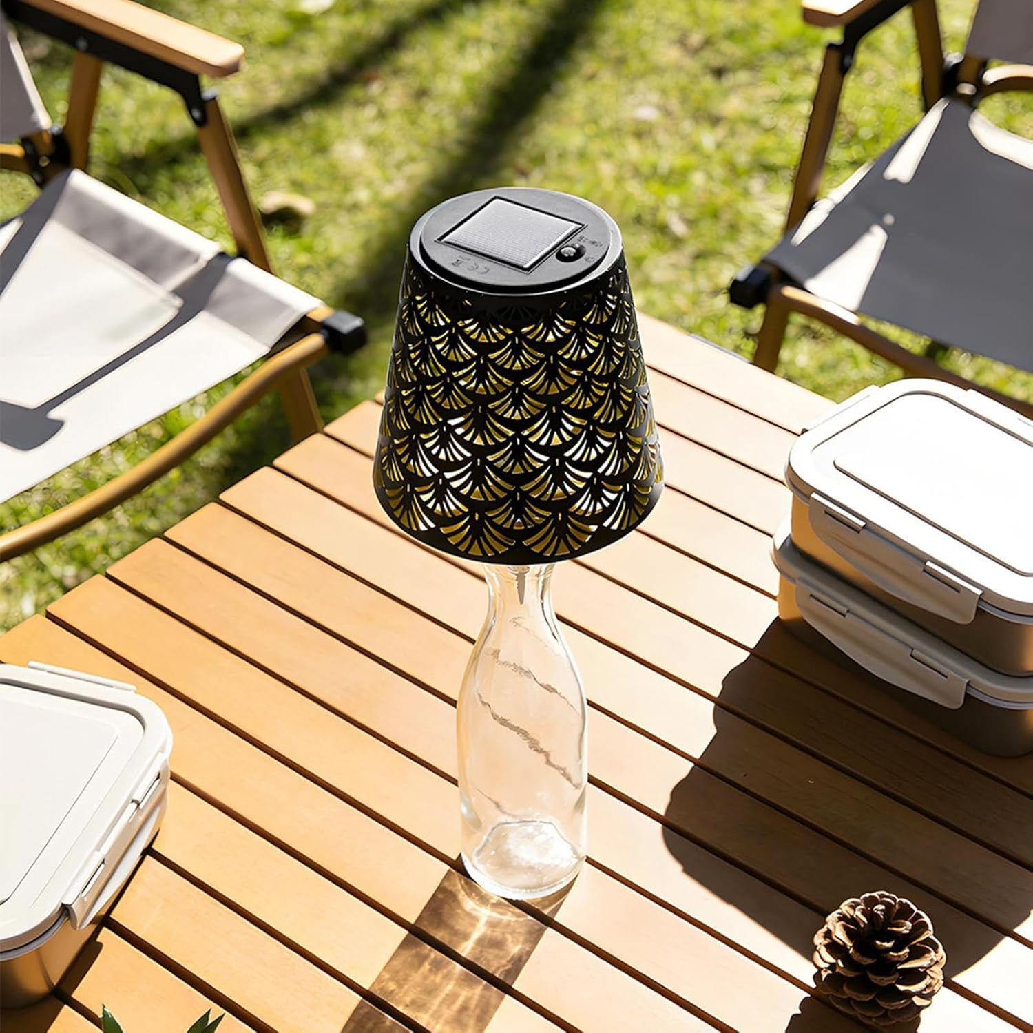 Ein Solarlicht auf einer Glasflasche auf einem Holztisch im Freien.