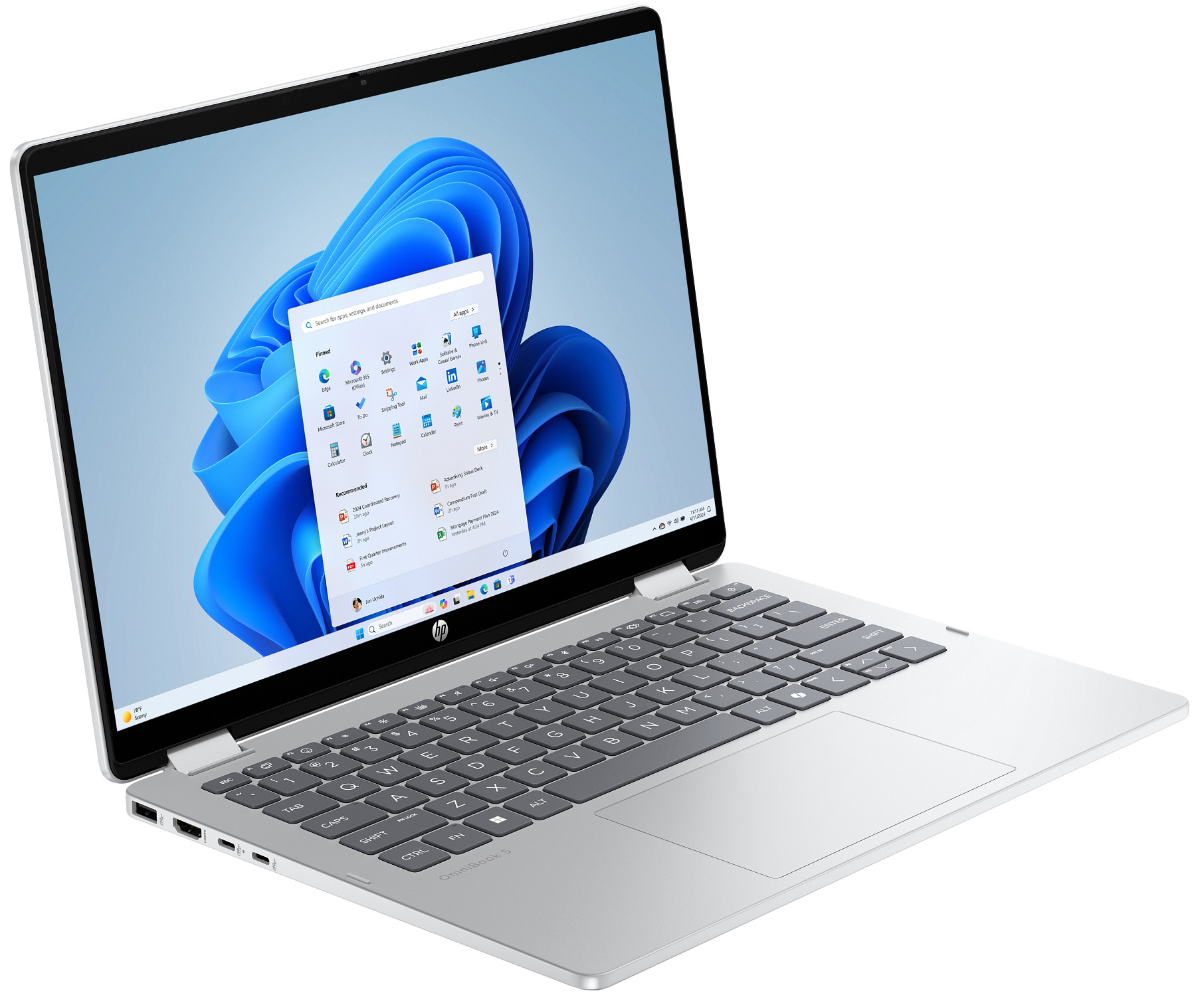 Ein offener silberner Laptop mit Windows 11-Startmenü auf dem Bildschirm.