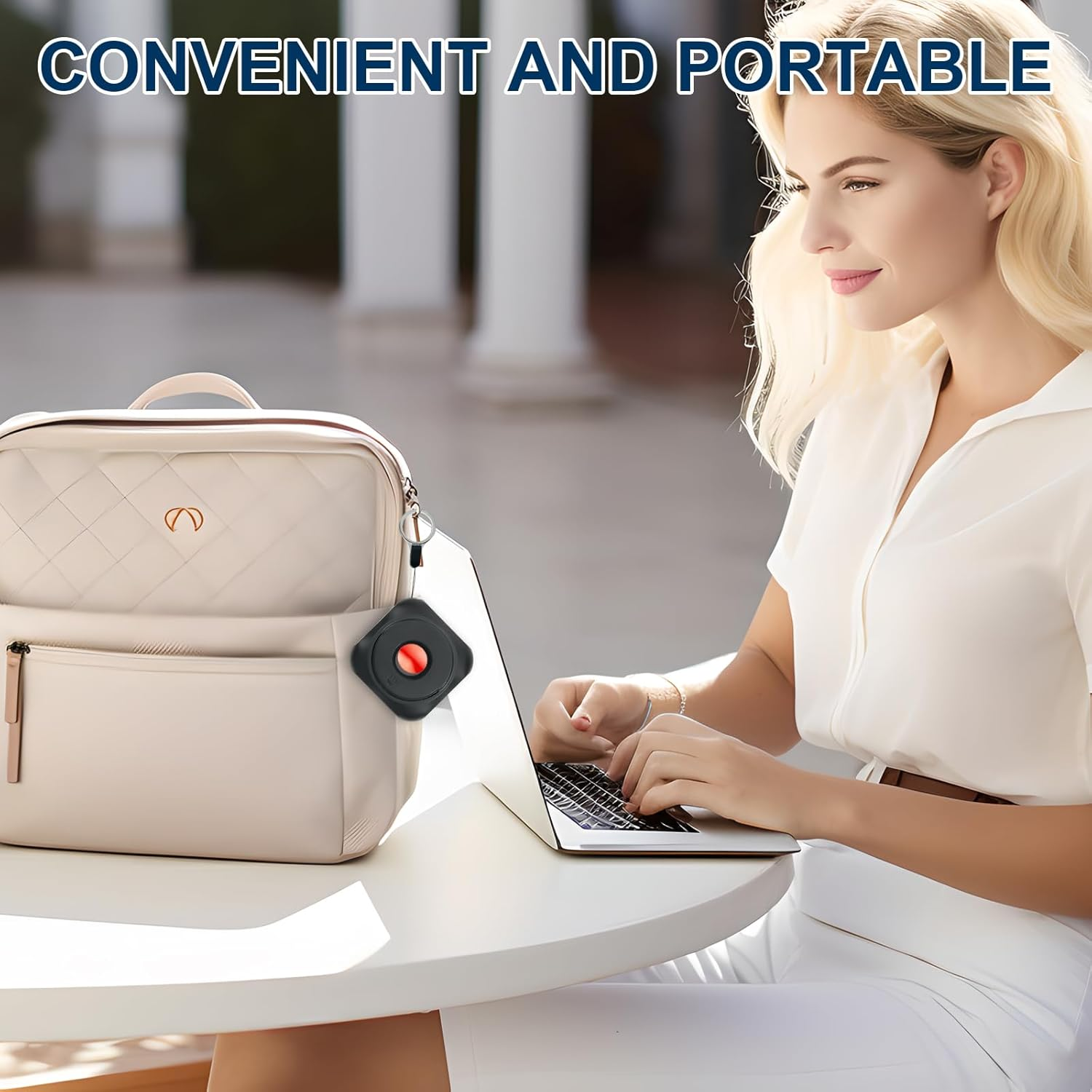 Eine Frau mit blonden Haaren tippt auf einem Laptop, daneben eine beige Tasche mit Anhänger.