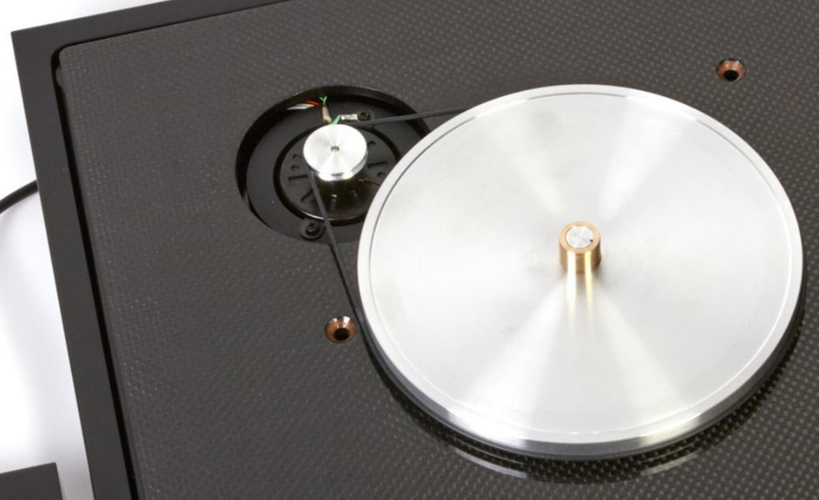 Zbliżenie talerza gramofonu z napędem paskowym i mechanizmem.