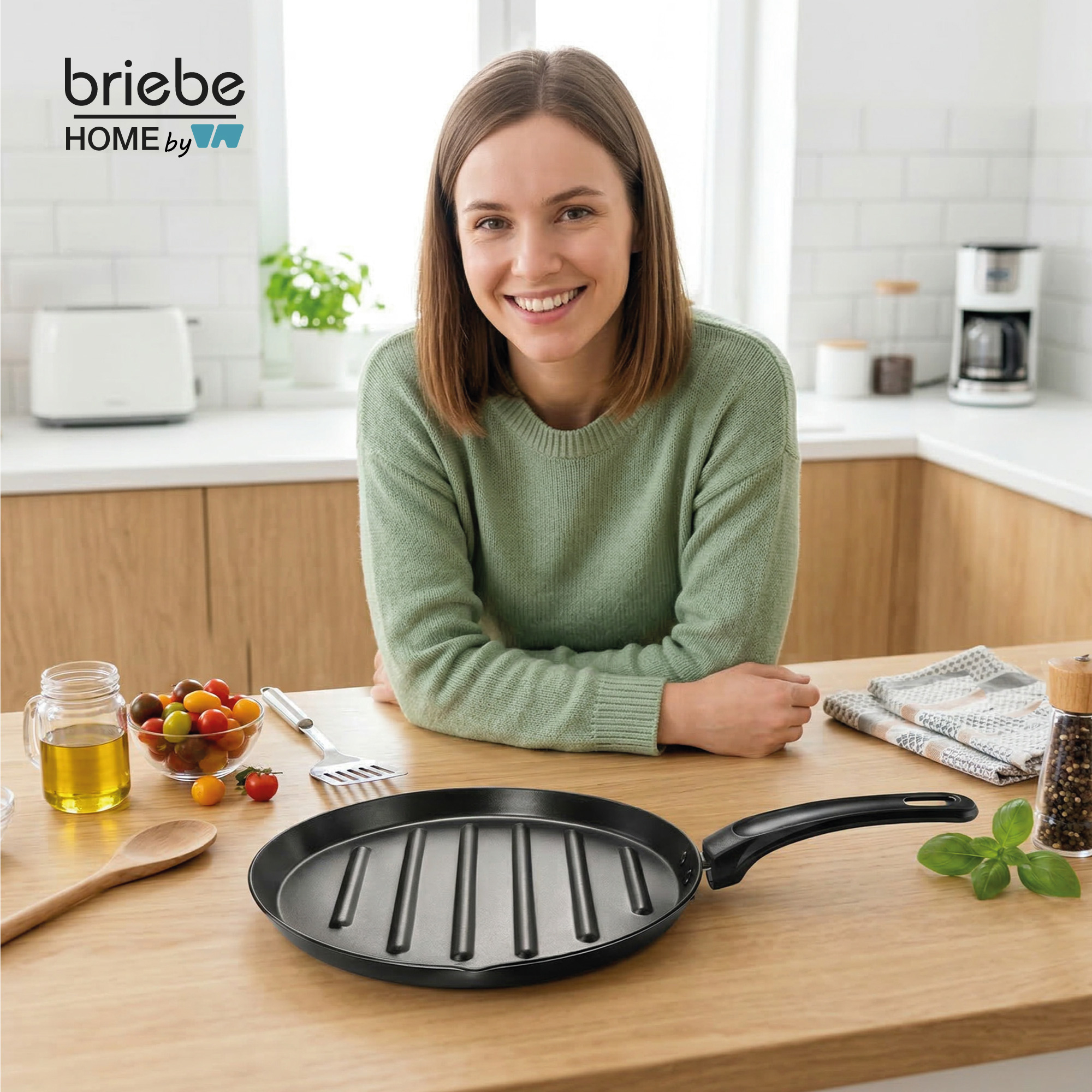 Eine Frau in einem grünen Pullover lächelt über einem Grillpfanne mit Tomaten und Öl.