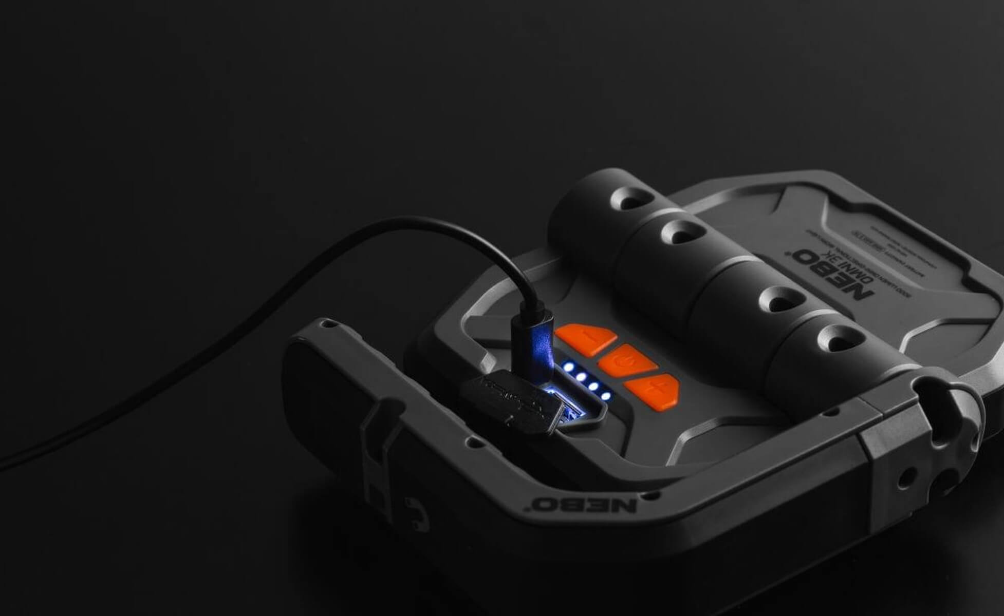 Ein schwarzes NEBO OMNI 3K-Gerät mit orangefarbenen Tasten und blauer Ladeanzeige.