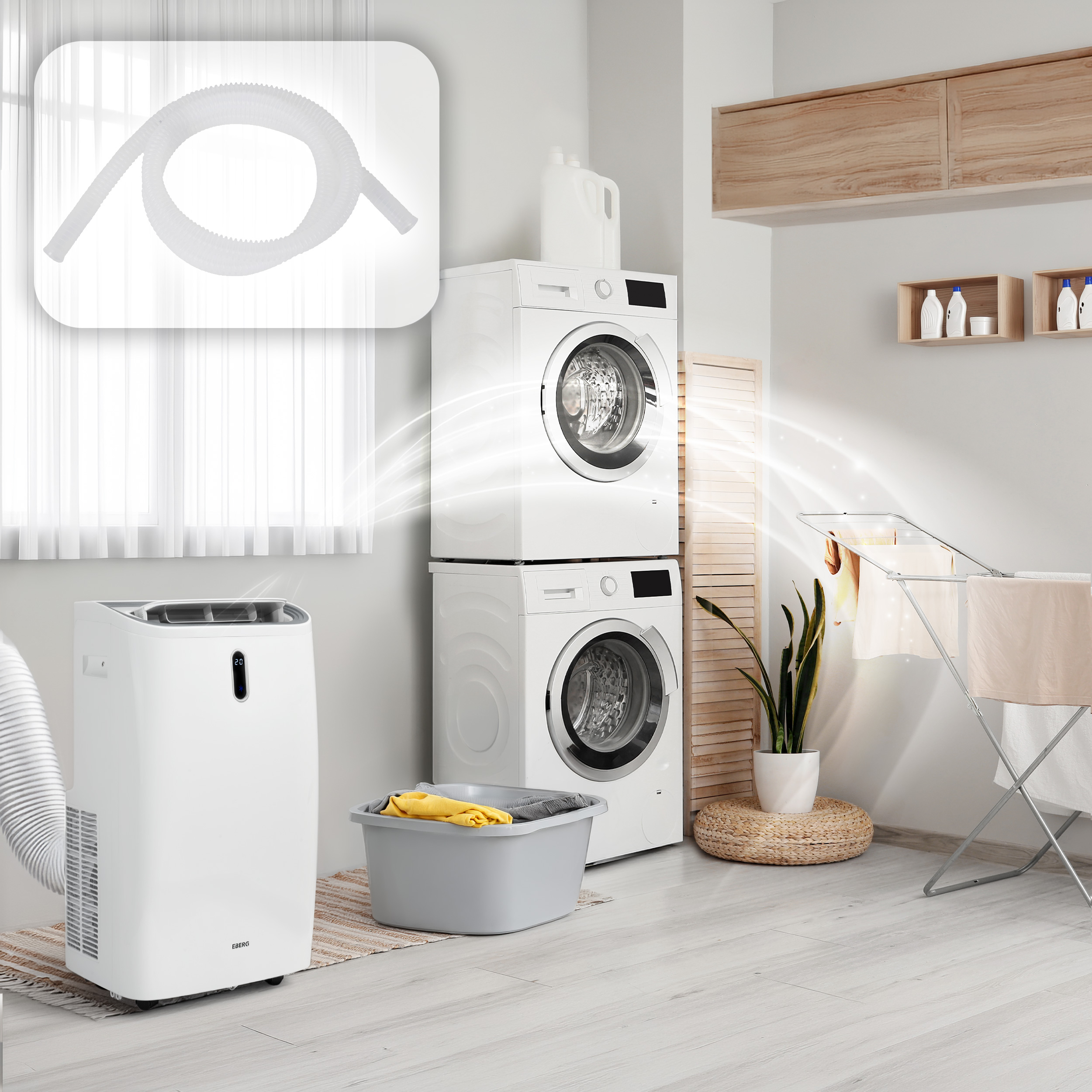 Biały przenośny klimatyzator obok pralki i suszarki na pranie.
