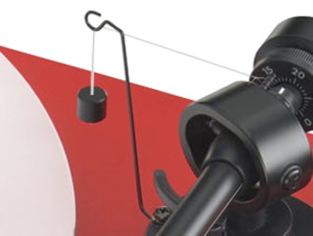 Czarny ramie z przeciwwagą i rysikiem na gramofonie. Czerwone tło.