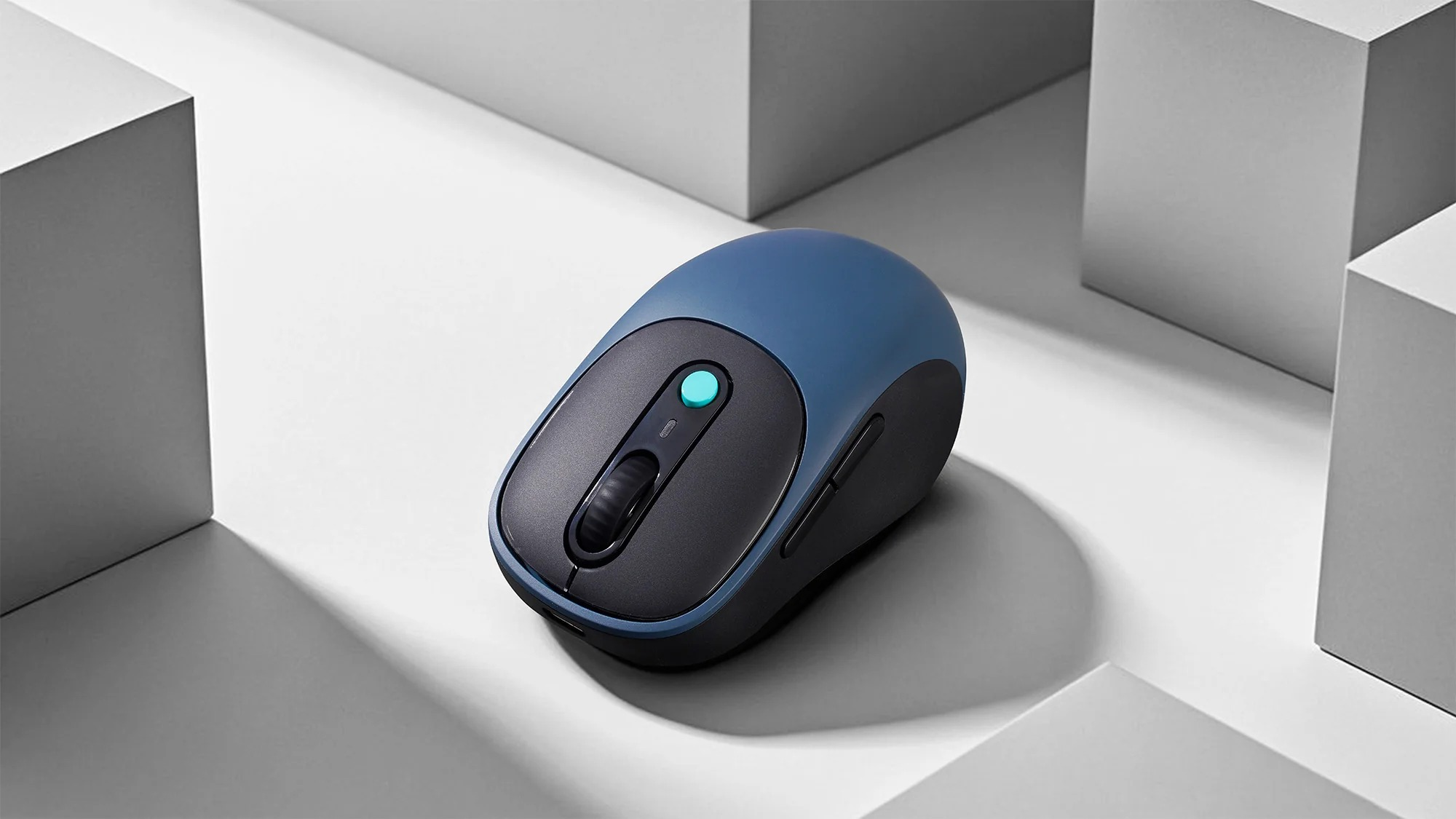 Niebiesko-czarna mysz komputerowa na białym postumencie.