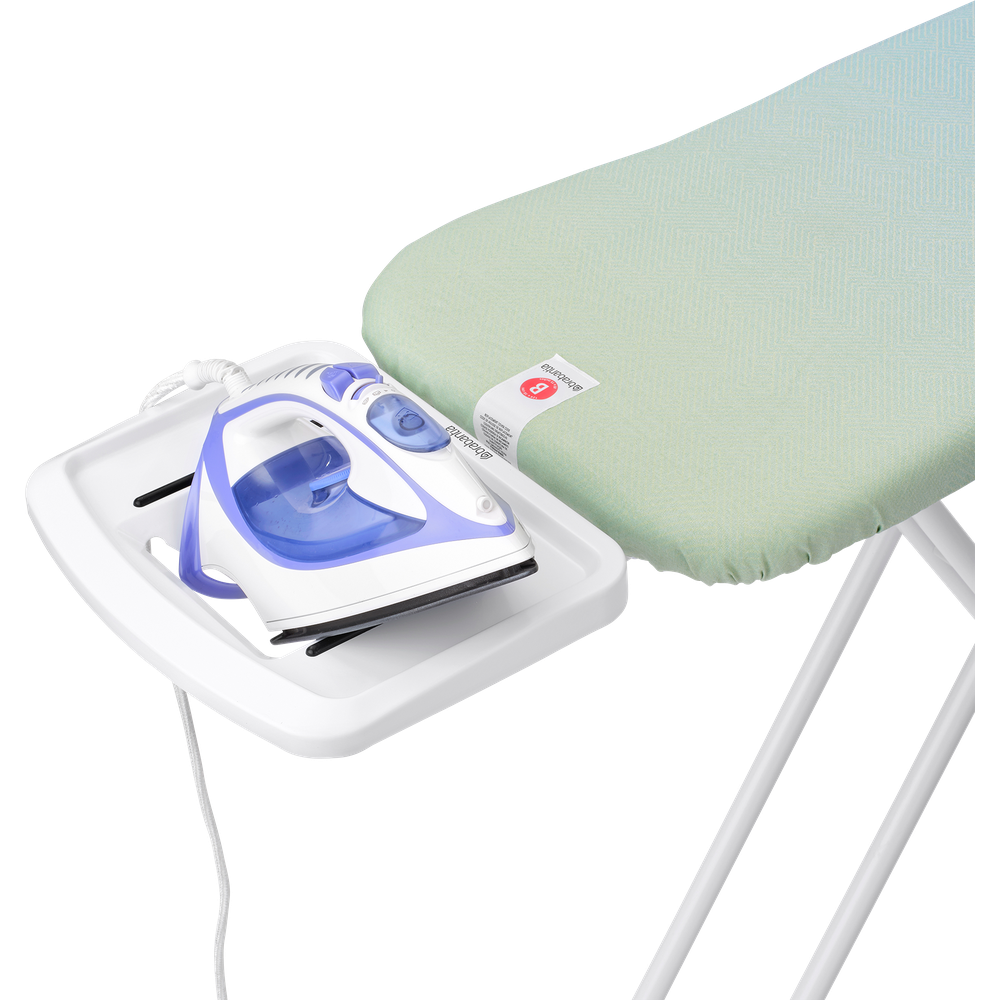 A steam iron rests on a white plastic holder attached to an ironing board.