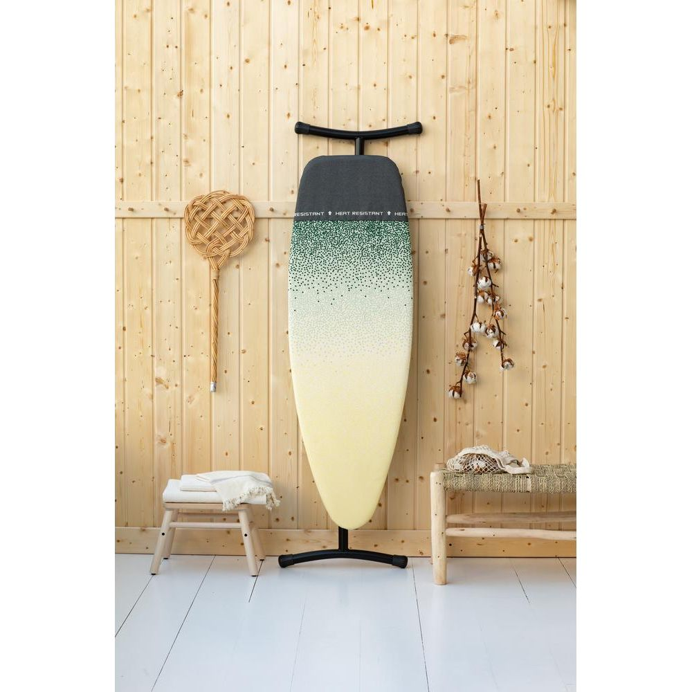 Table à repasser à motif, dressée sur un support, avec décor en bois en arrière-plan.