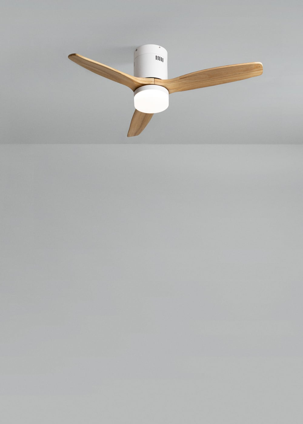 Un ventilador de techo moderno con tres aspas de madera y luz integrada.
