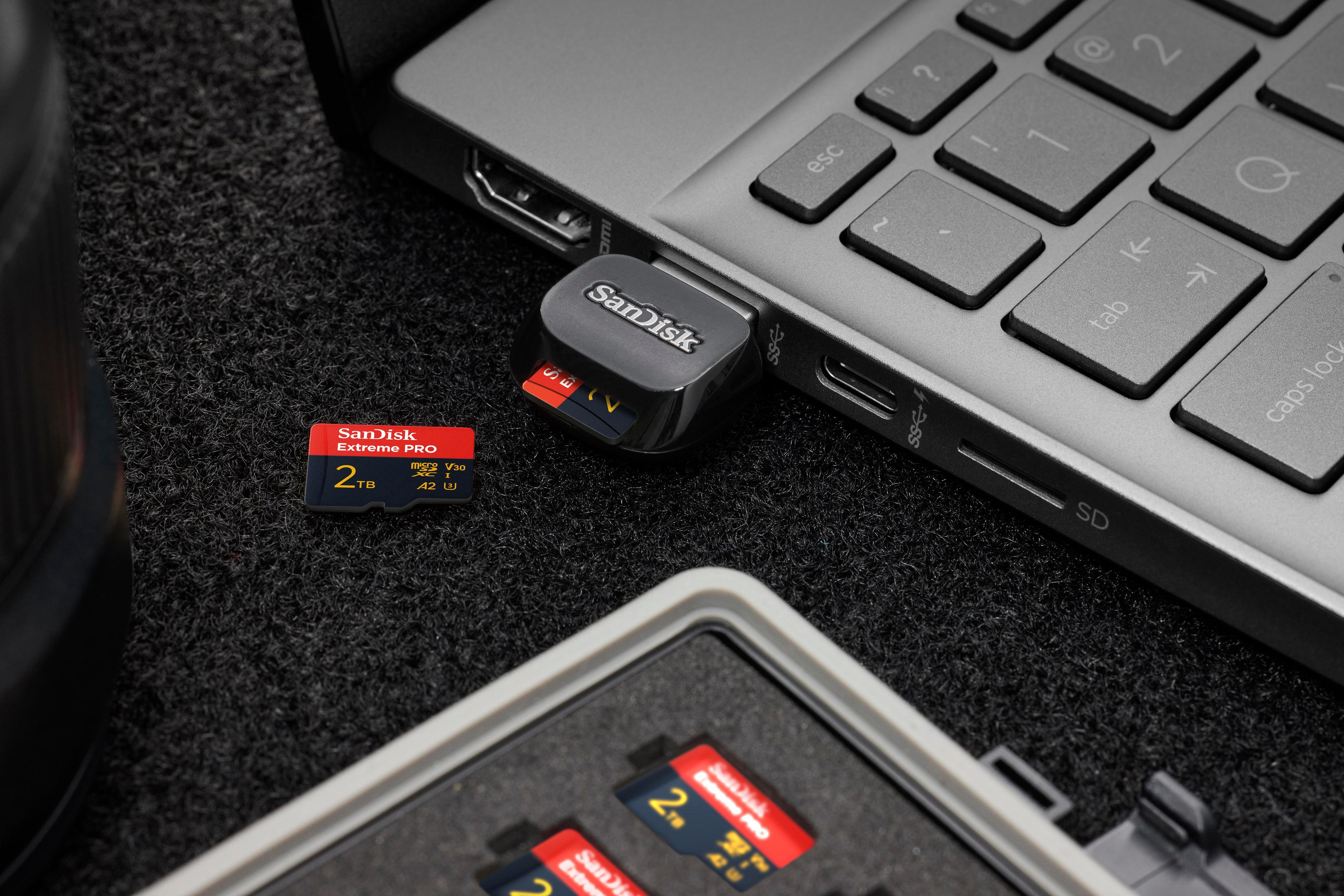 Schede di memoria SanDisk e un adattatore inseriti in un laptop.