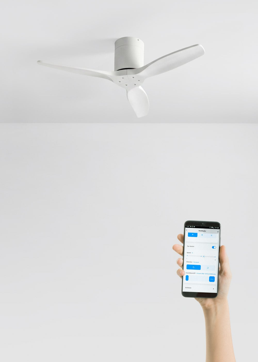 Control de ventilador de techo blanco con un teléfono inteligente en la mano.
