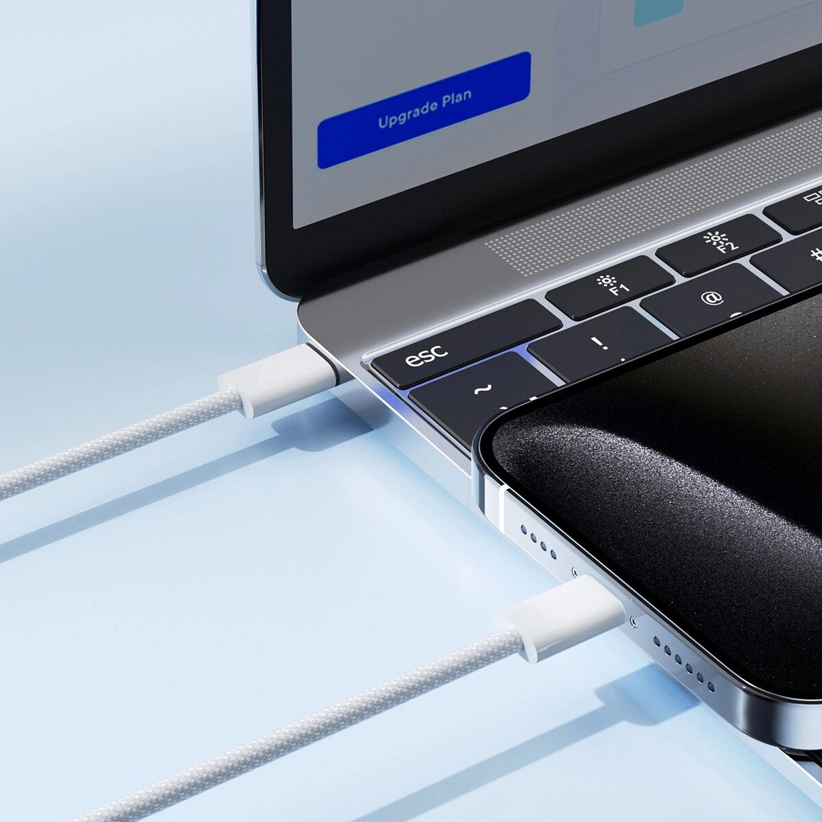 Ein weißes Kabel verbindet ein Smartphone mit einem Laptop über einen USB-C-Anschluss.