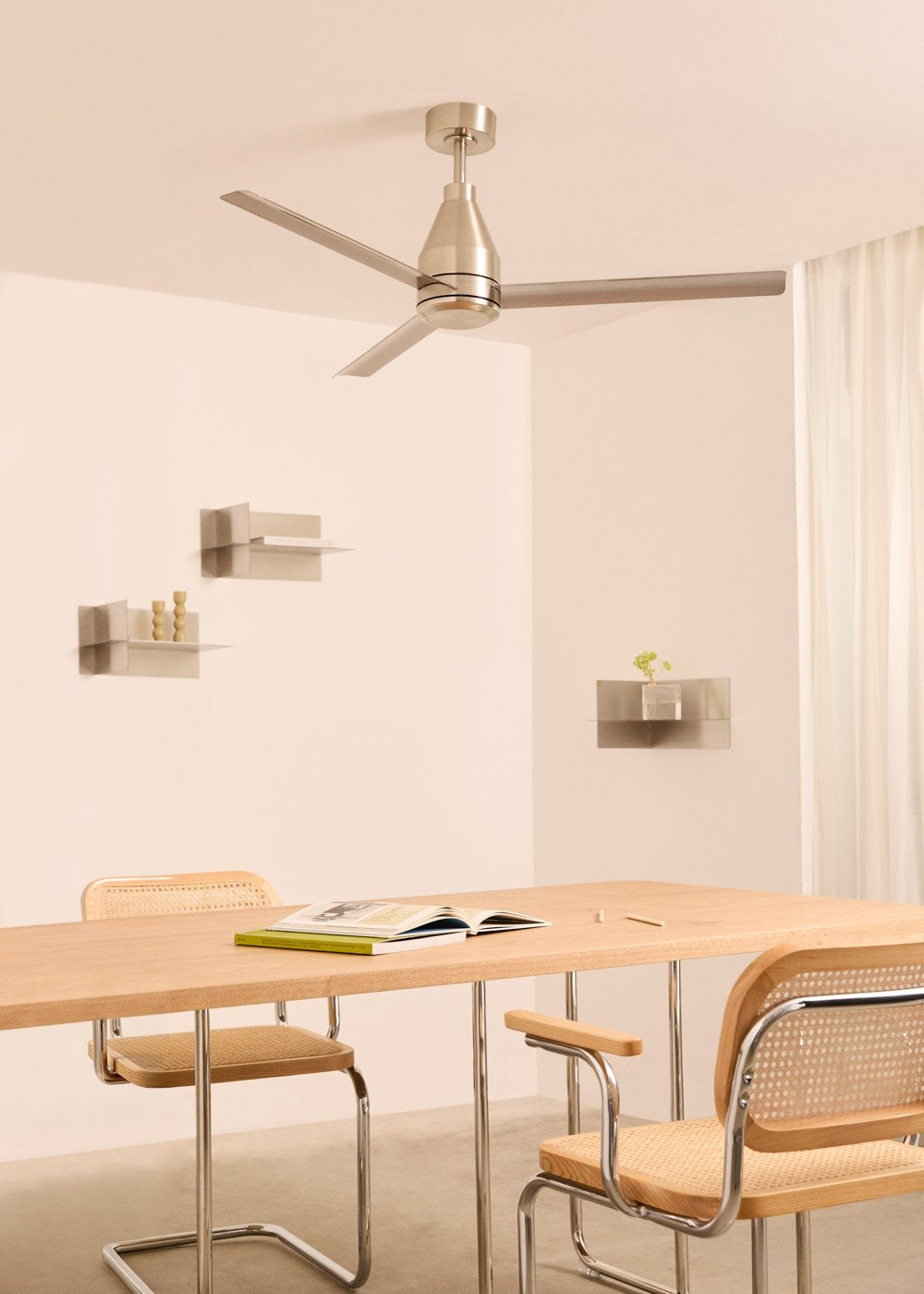 Una habitación con mesa de comedor, sillas, ventilador de techo y estantes.