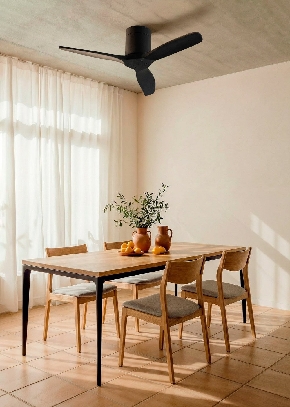 Ventilador de techo negro sobre mesa de comedor de madera con cuatro sillas, decorado con jarrones y naranjas.