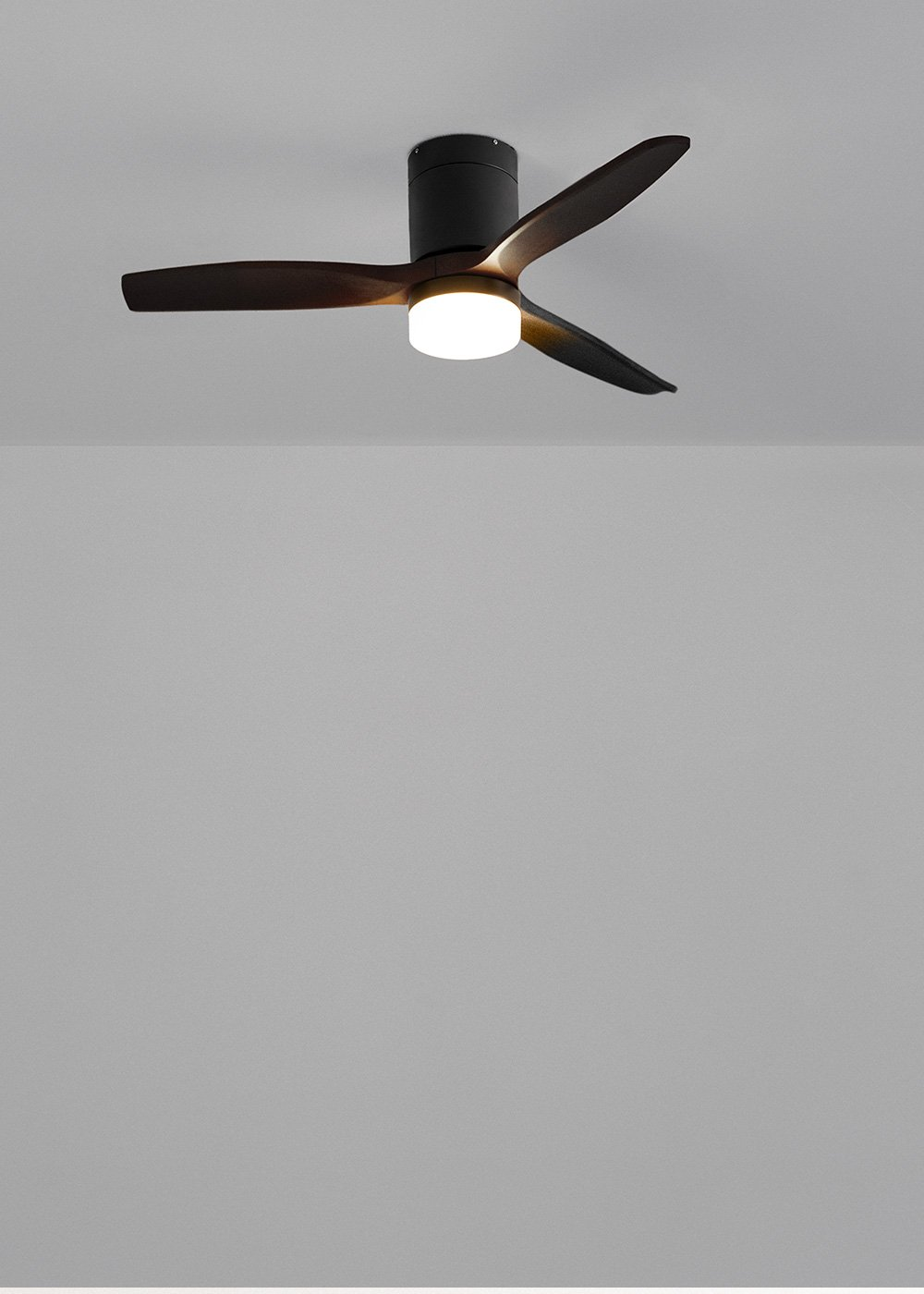 Un ventilador de techo negro con tres aspas de madera marrón y una luz redonda.