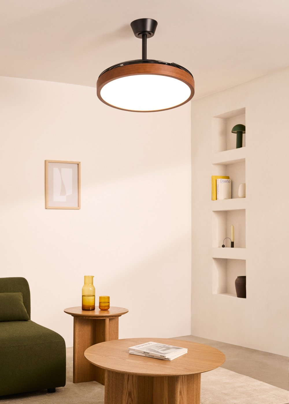 Una sala de estar con lámpara de ventilador de techo, sofá, mesa de centro y estantes.