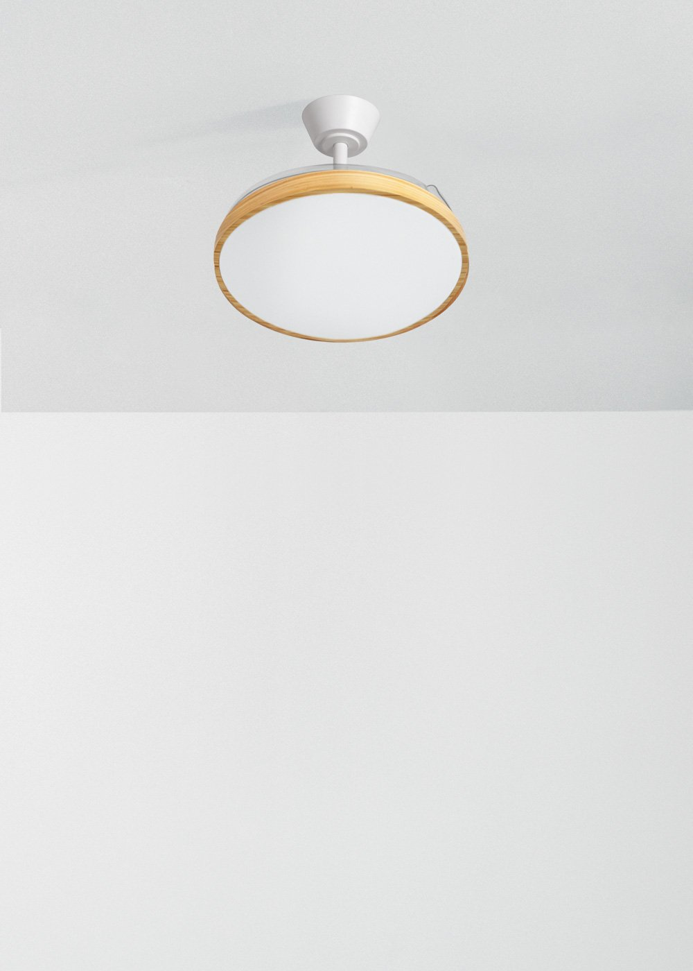 Un ventilador de techo blanco con borde de madera y luz de cristal esmerilado está montado en un techo blanco.