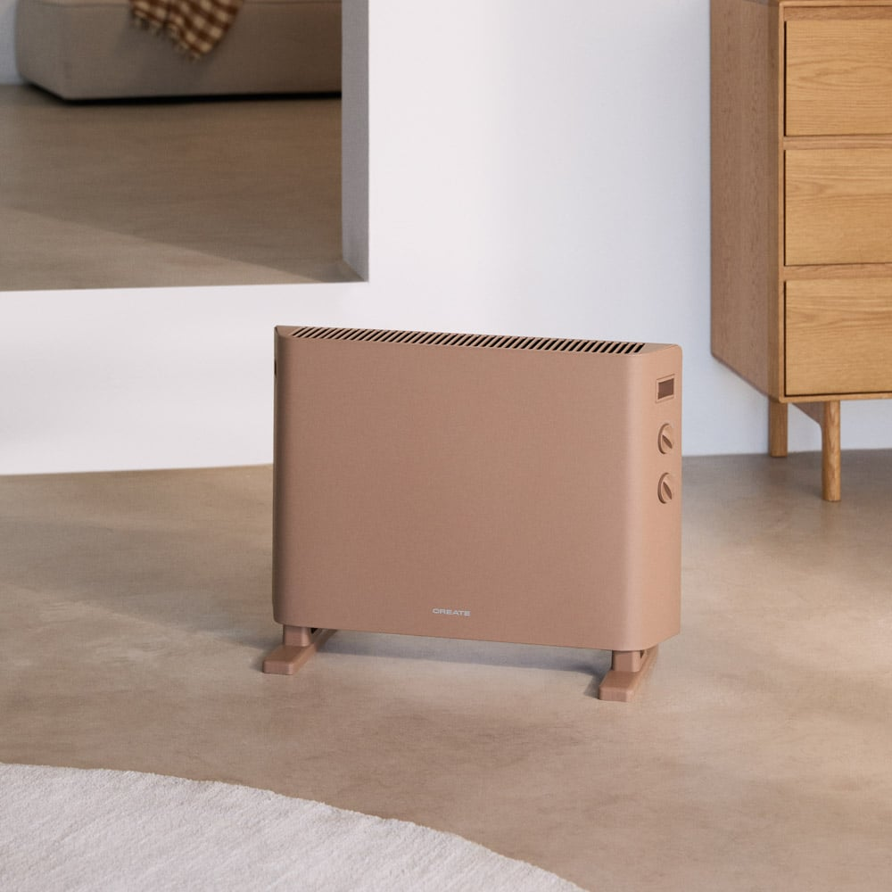 Un radiador beige sobre suelo claro, frente a un armario de madera.