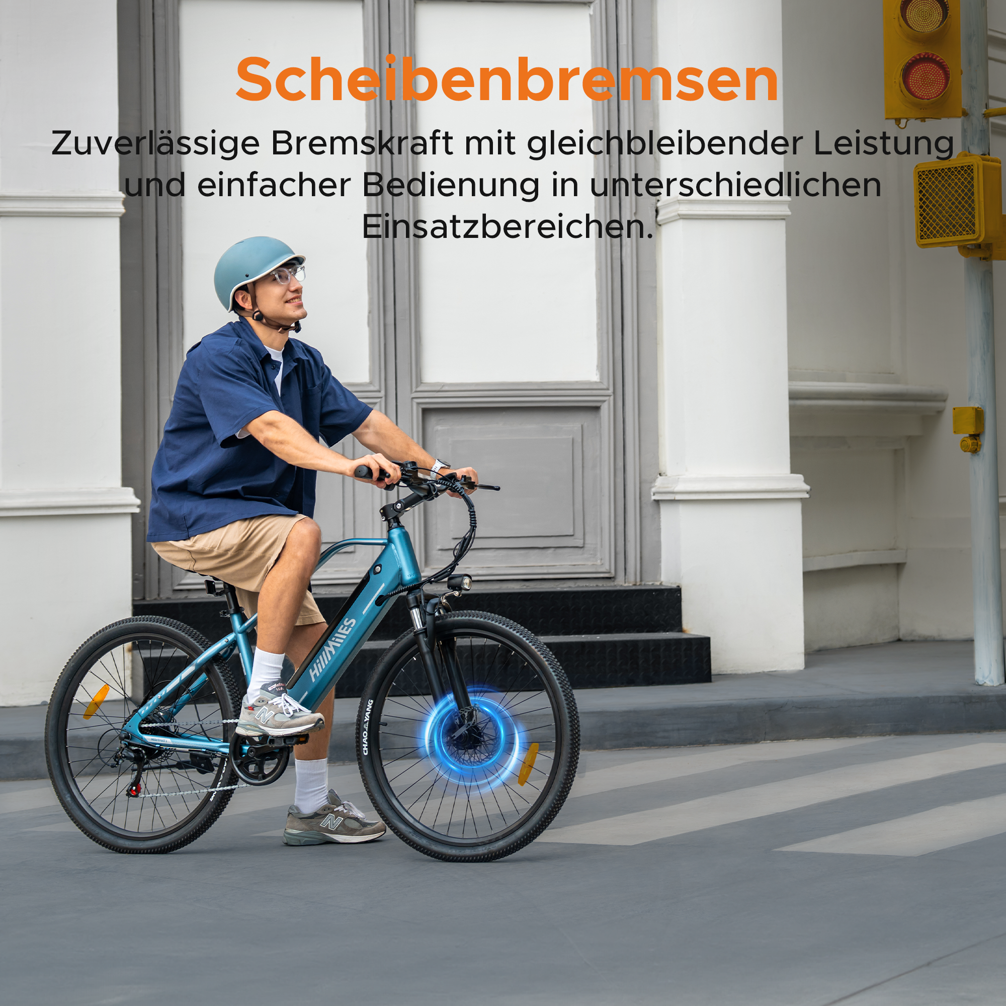 Hombre monta bicicleta eléctrica azul con casco y gafas en acera.