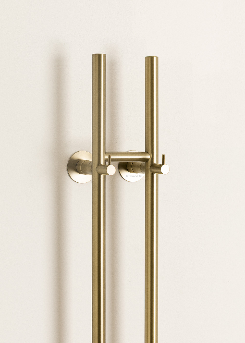 Un soporte dorado para alcachofa de ducha con dos tubos verticales y un asa horizontal.