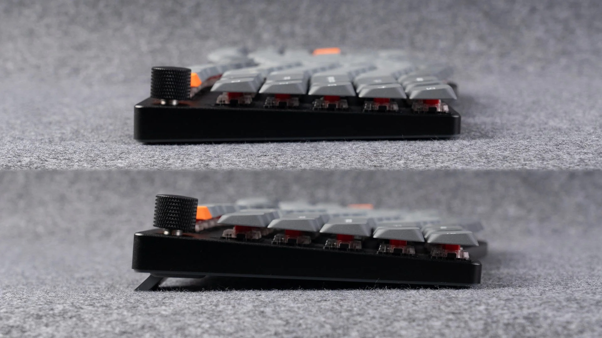 Szara klawiatura z czarnymi i pomarańczowymi akcentami na szarej wykładzinie.