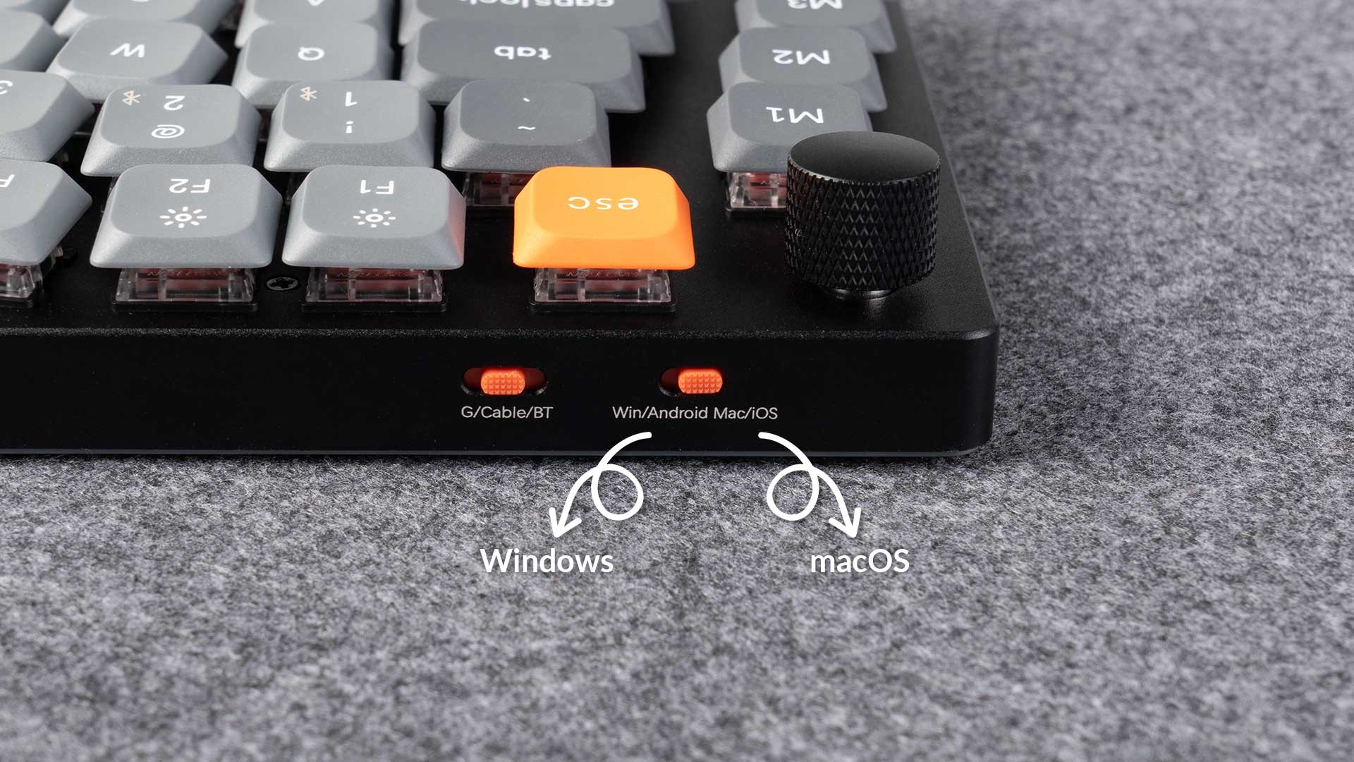 Zbliżenie czarnej klawiatury z szarymi klawiszami i pomarańczowym klawiszem ESC.