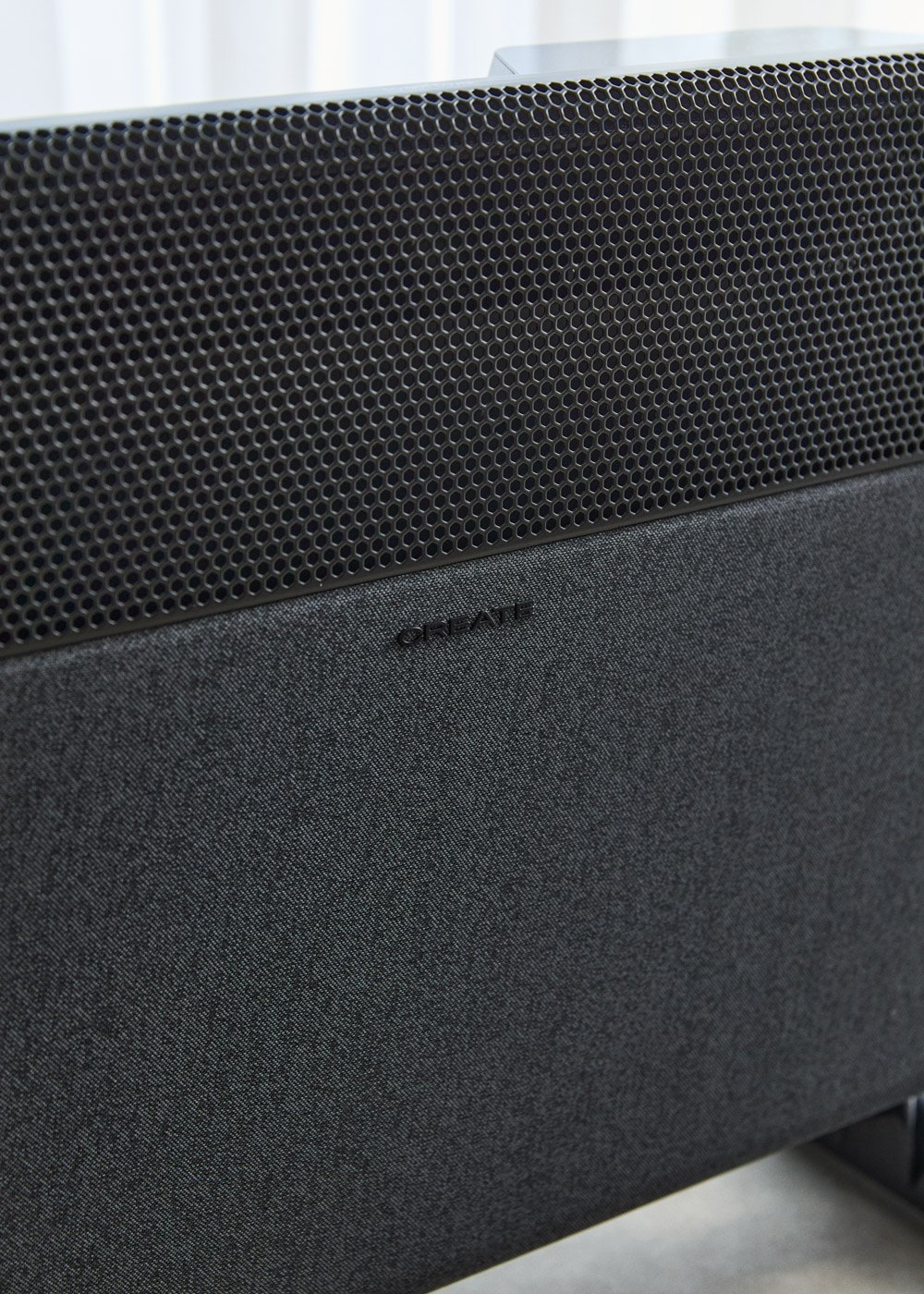 Un altavoz negro con parte superior perforada y cubierta de tela. La palabra "CREATE" está grabada.