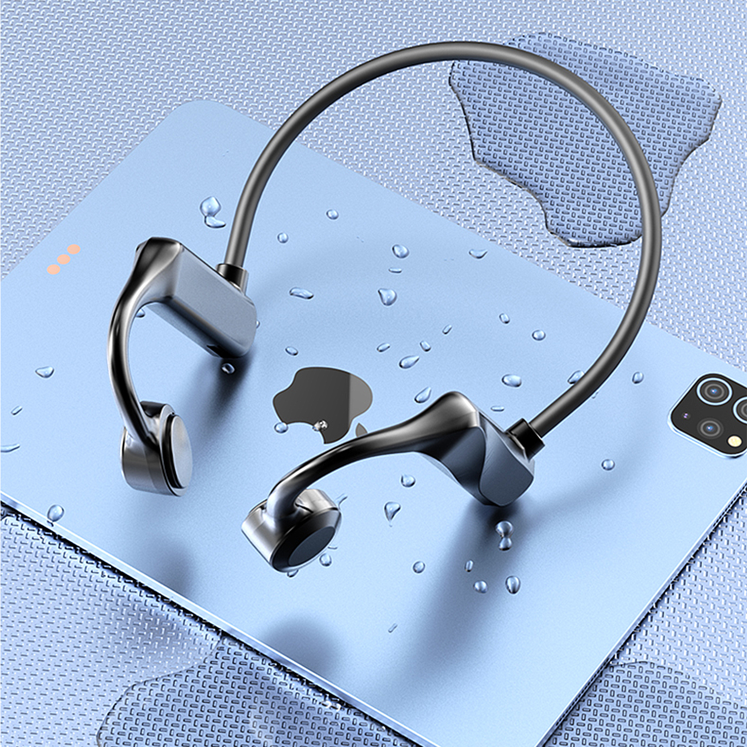 Cuffie nere su un tablet blu con gocce d'acqua.