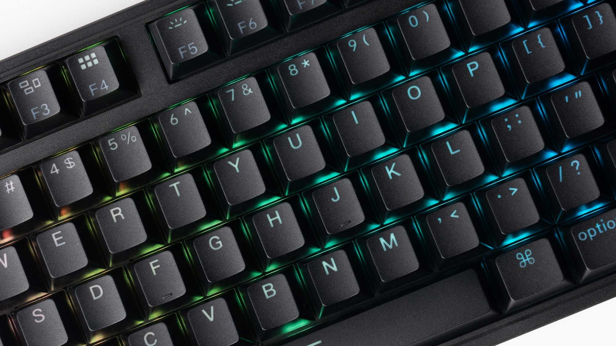 Zbliżenie czarnej klawiatury z kolorowym podświetleniem RGB klawiszy.