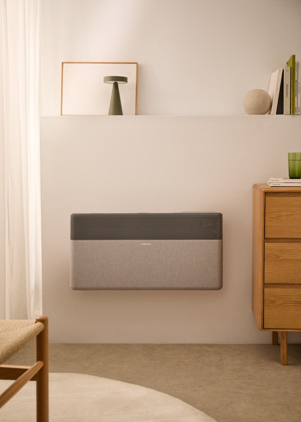Un radiador gris montado en la pared, junto a un mueble de madera y una silla.