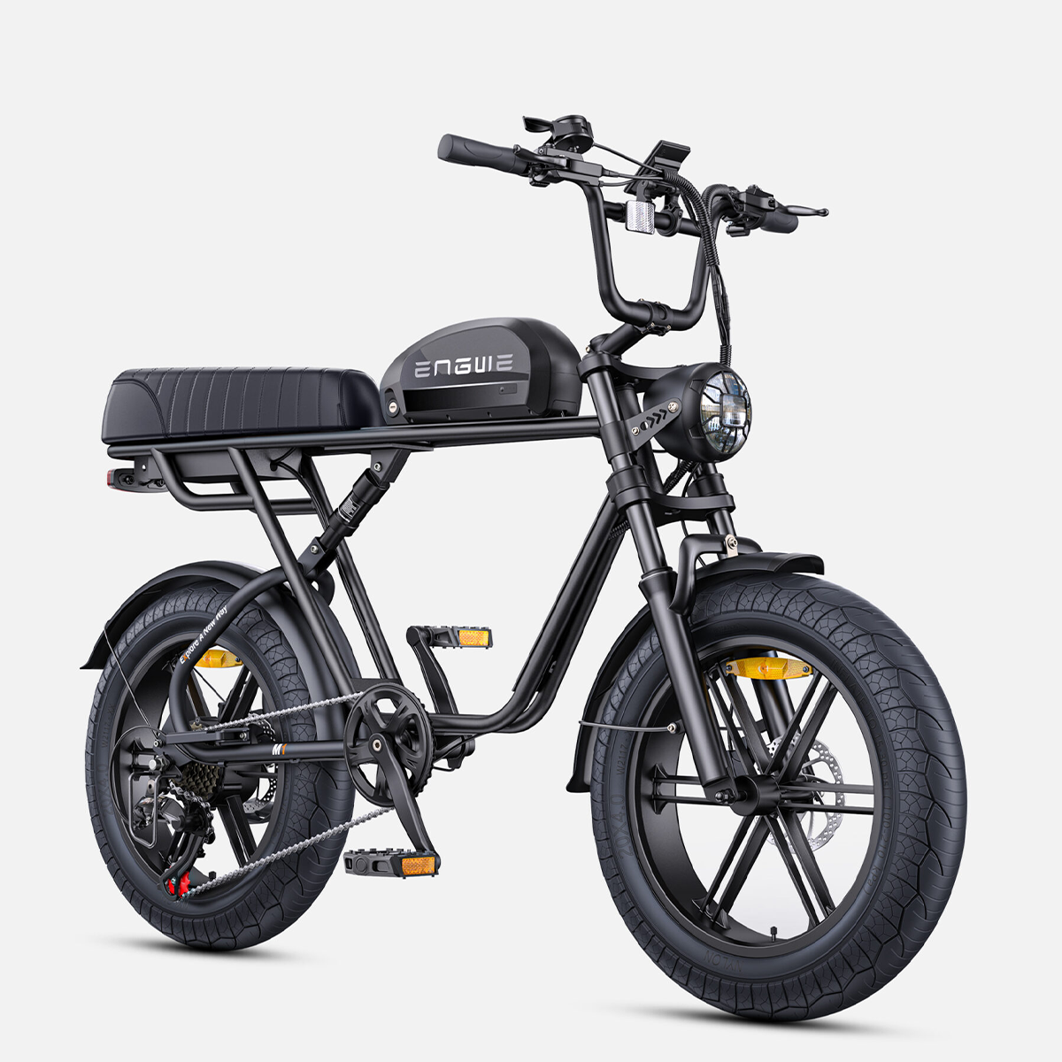 Czarny rower elektryczny z szerokimi oponami, amortyzatorem przednim i tylnym światłem.