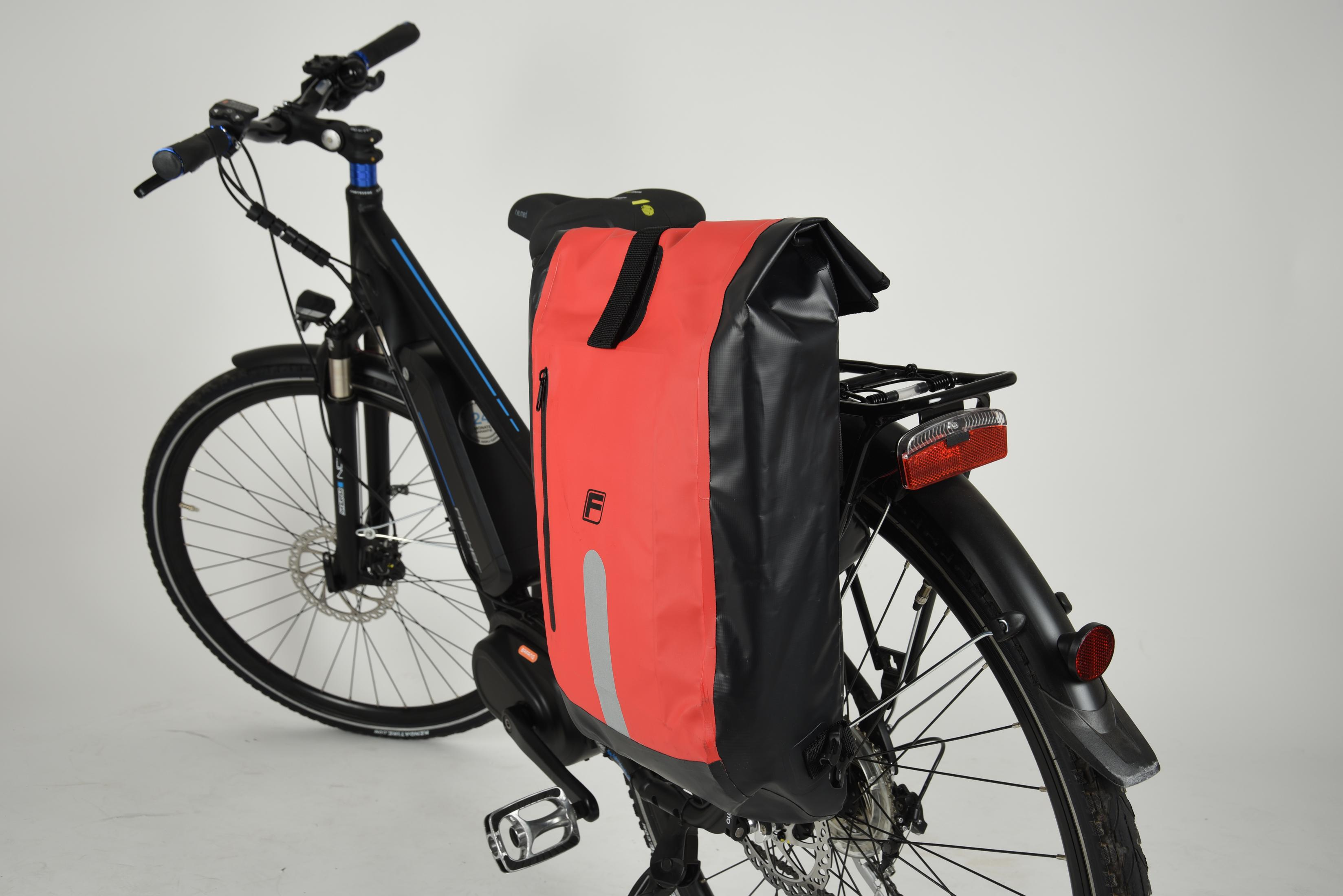 Ein schwarzes Fahrrad mit roter und schwarzer Gepäcktasche, auf weißem Hintergrund.