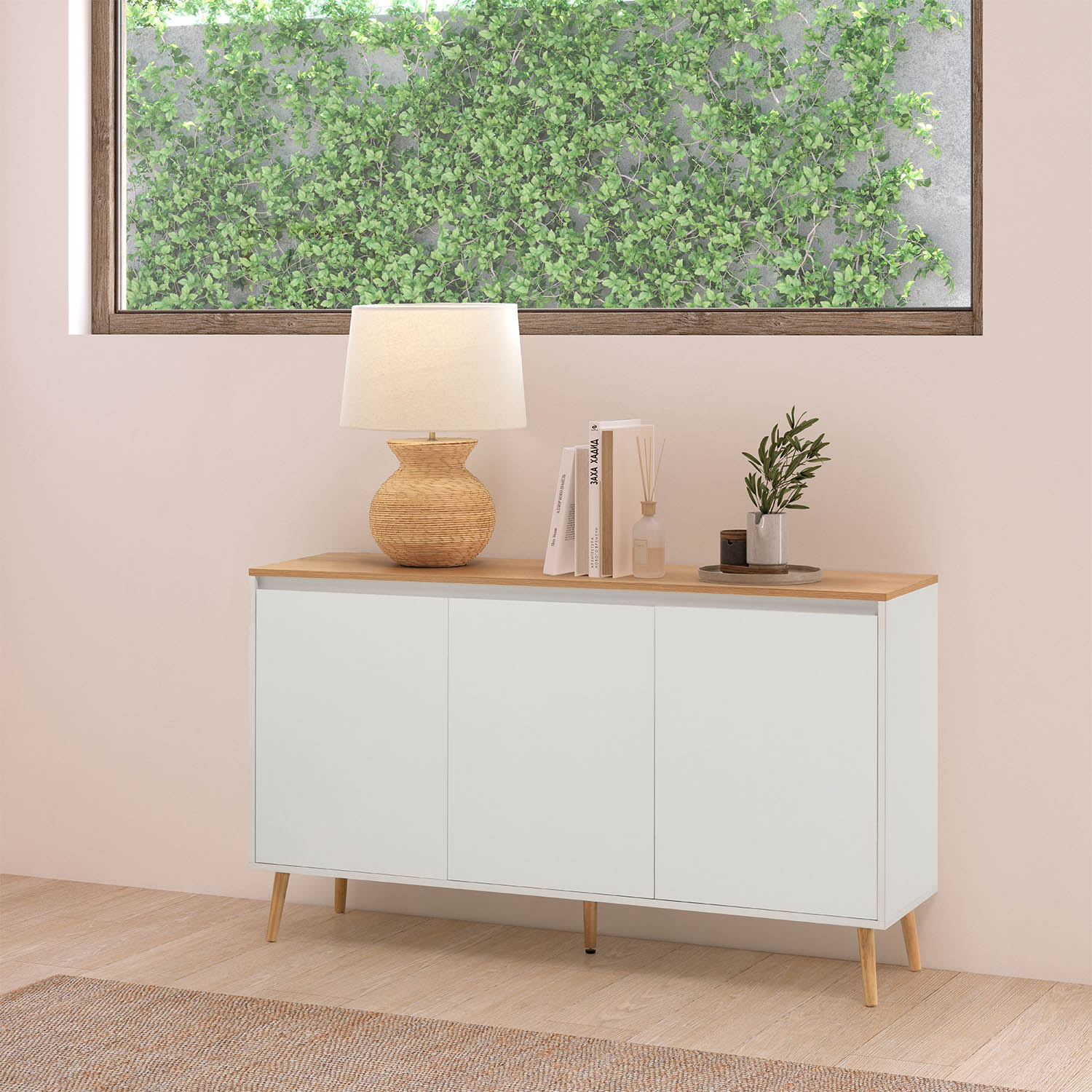 Un mueble blanco con tapa de madera, con lámpara, libros y planta.
