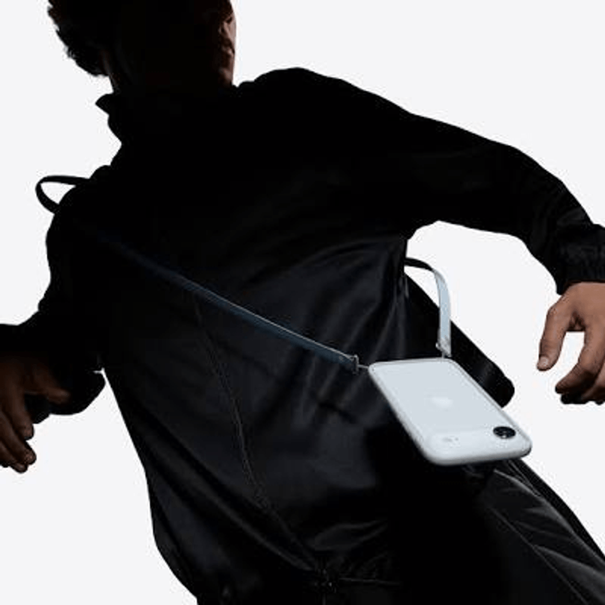 Una persona viste un atuendo negro con una funda de teléfono blanca.