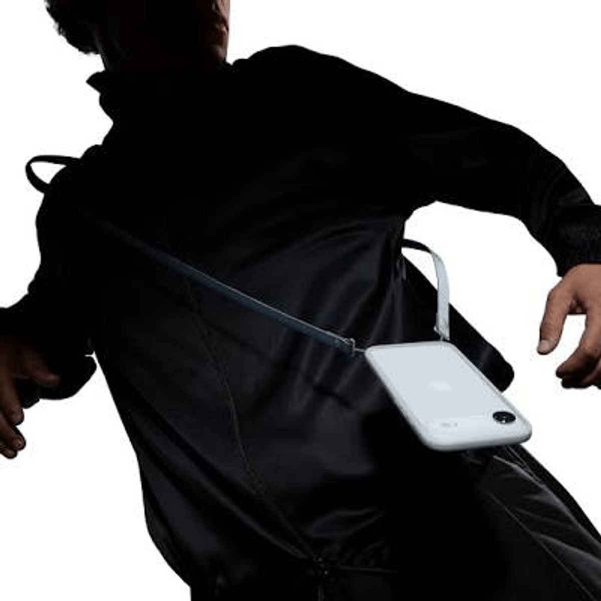 Una persona con ropa negra lleva un smartphone blanco con cordón.