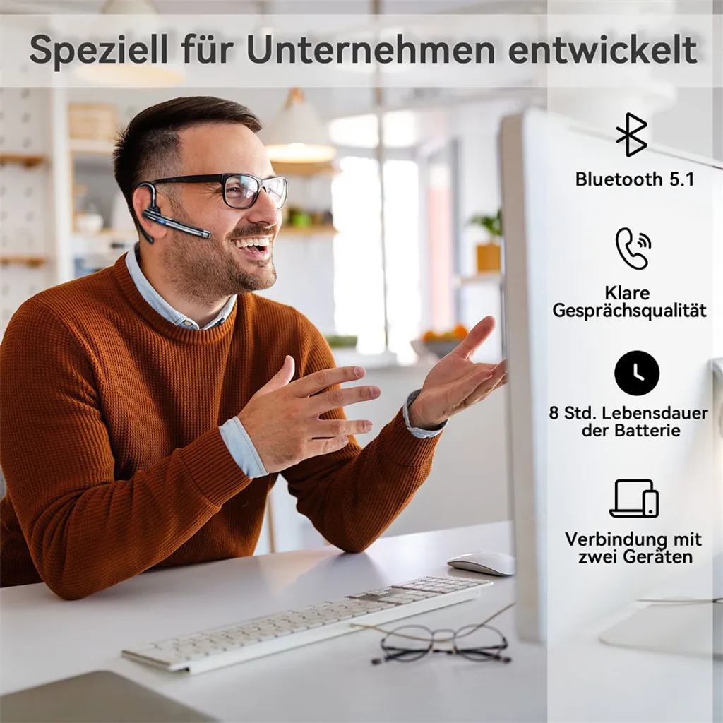 Mann im braunen Pullover mit Headset am Schreibtisch, spricht.