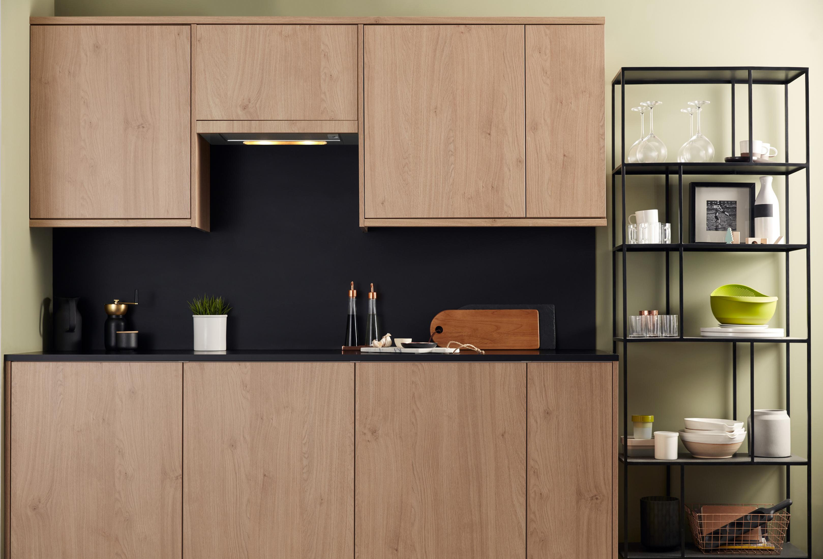 Cocina moderna con gabinetes de madera, encimera negra y estantería abierta.