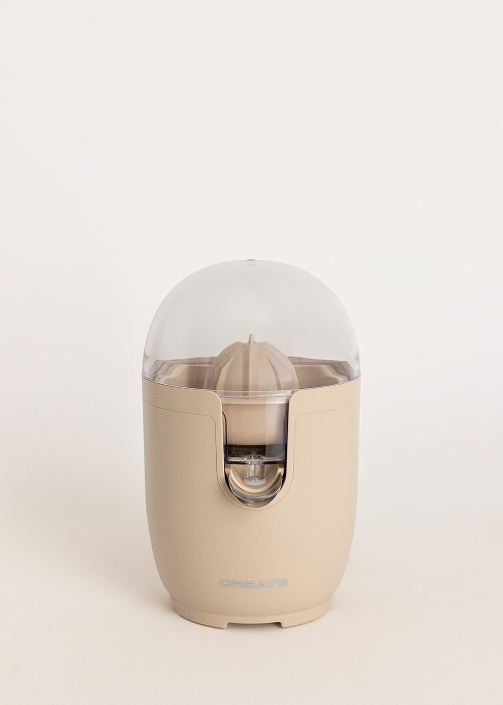 Un exprimidor eléctrico beige con tapa transparente y depósito.
