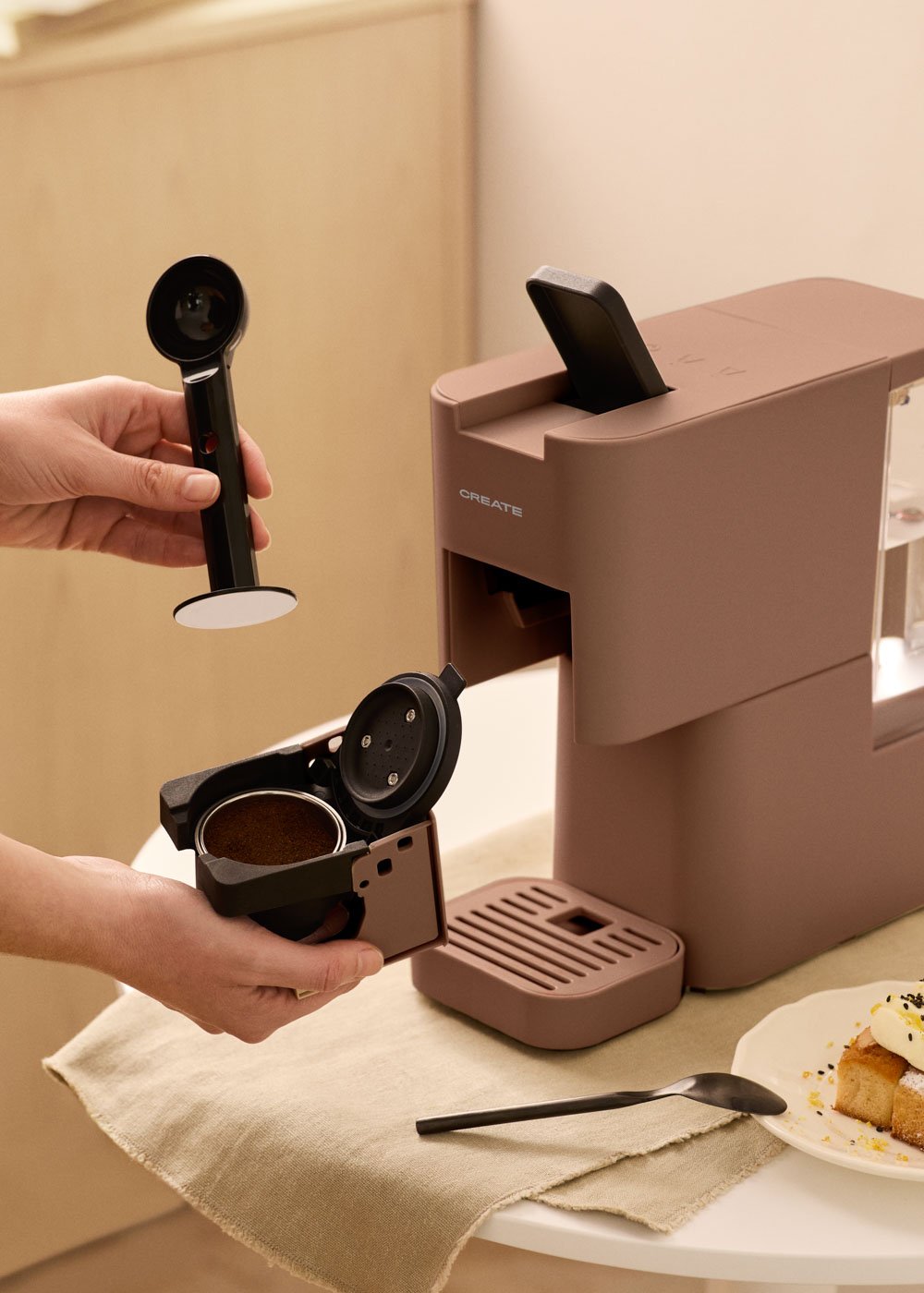 Una persona prepara una cafetera añadiendo café molido a un soporte.