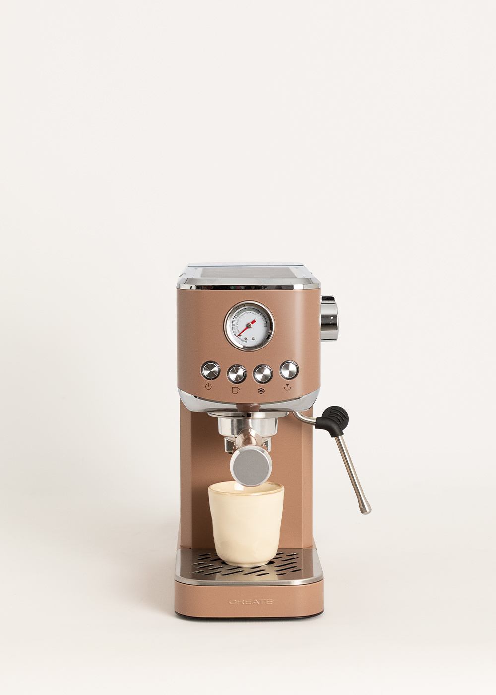 Una cafetera espresso color canela con una taza pequeña debajo y un manómetro.