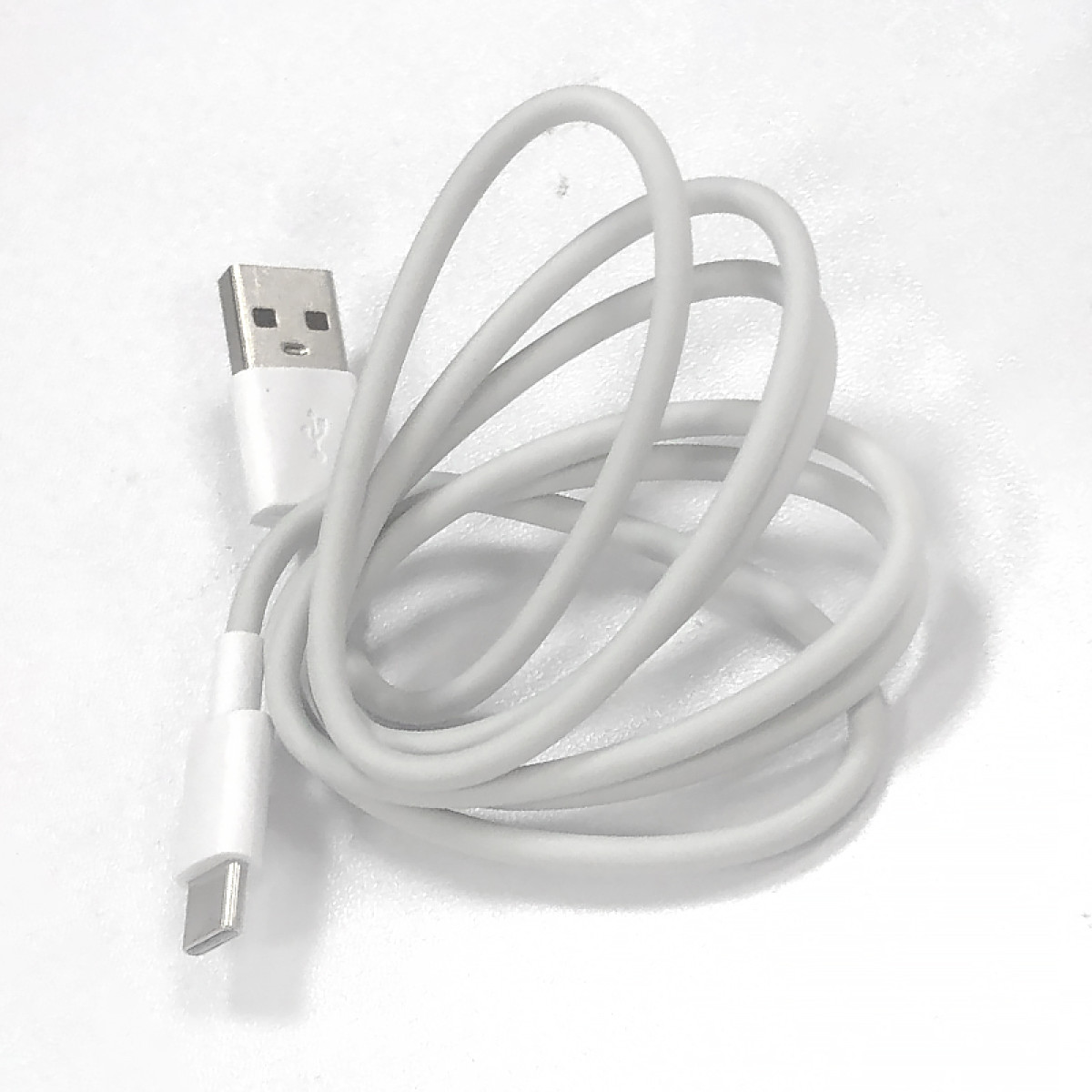 Ein weißes USB-C-zu-USB-A-Kabel auf weißer Oberfläche.