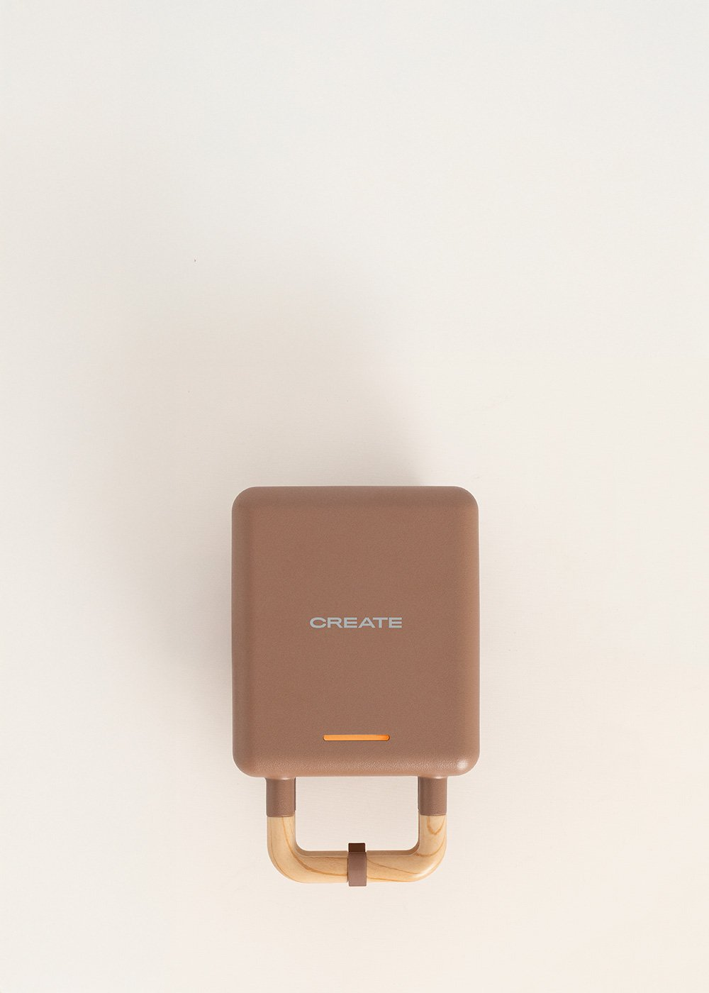 Máquina para hacer gofres marrón con asas de madera y la palabra "CREATE".