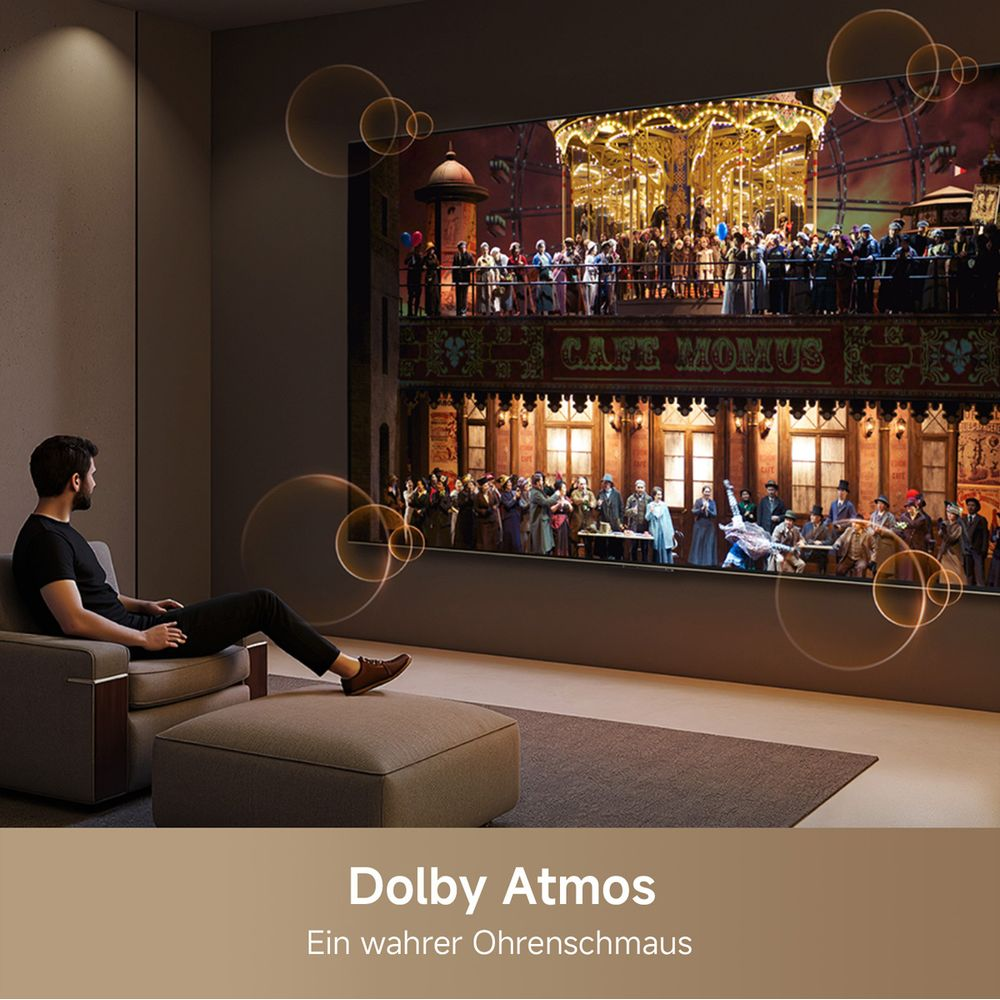 Hombre sentado en sofá viendo pantalla con escena de circo. Dolby Atmos.