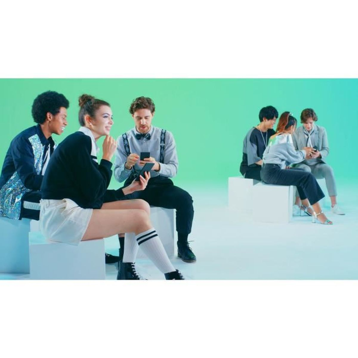 Persone sedute su cubi che usano smartphone con sfondo verde.