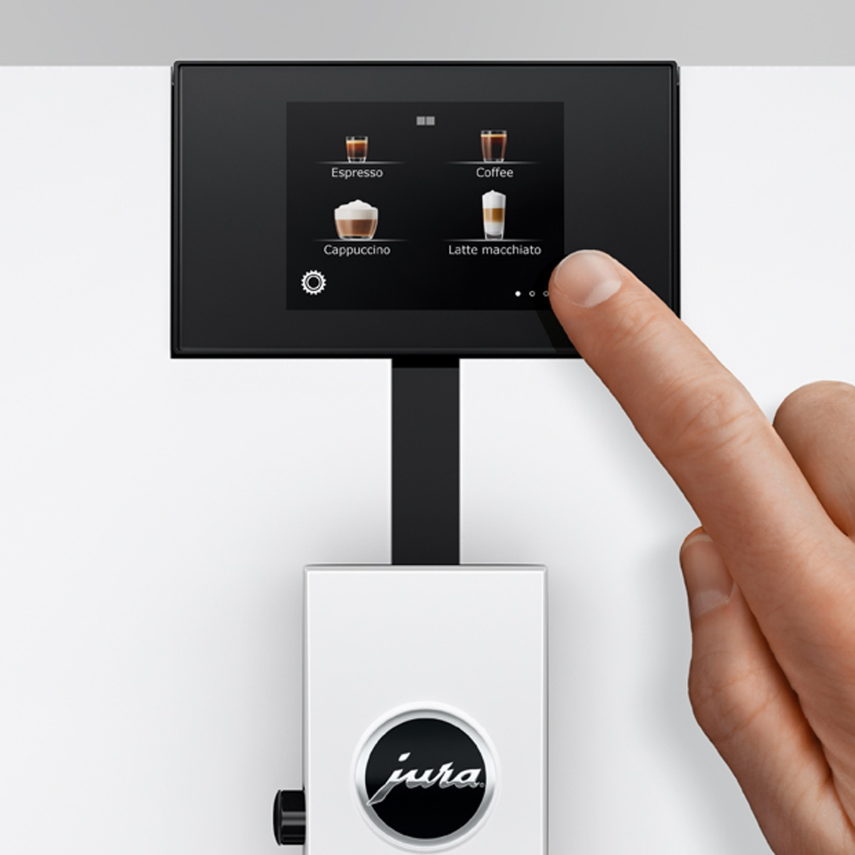 Un dito tocca il touchscreen di una macchina da caffè con opzioni.