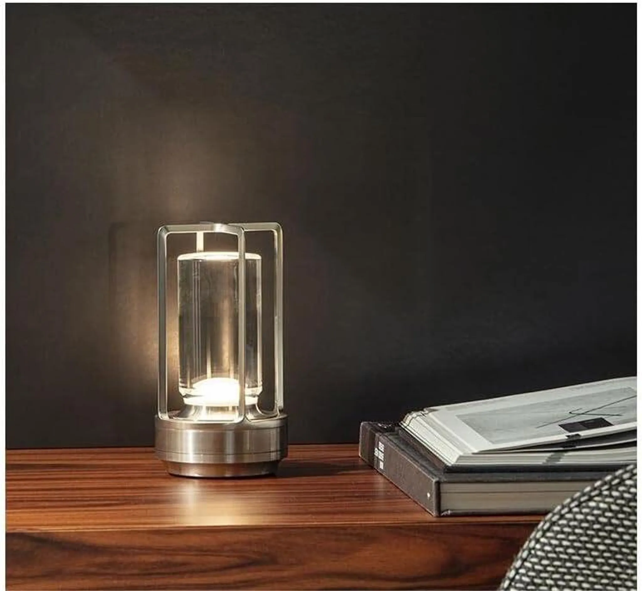 Eine moderne Lampe auf einem Holztisch neben Büchern.