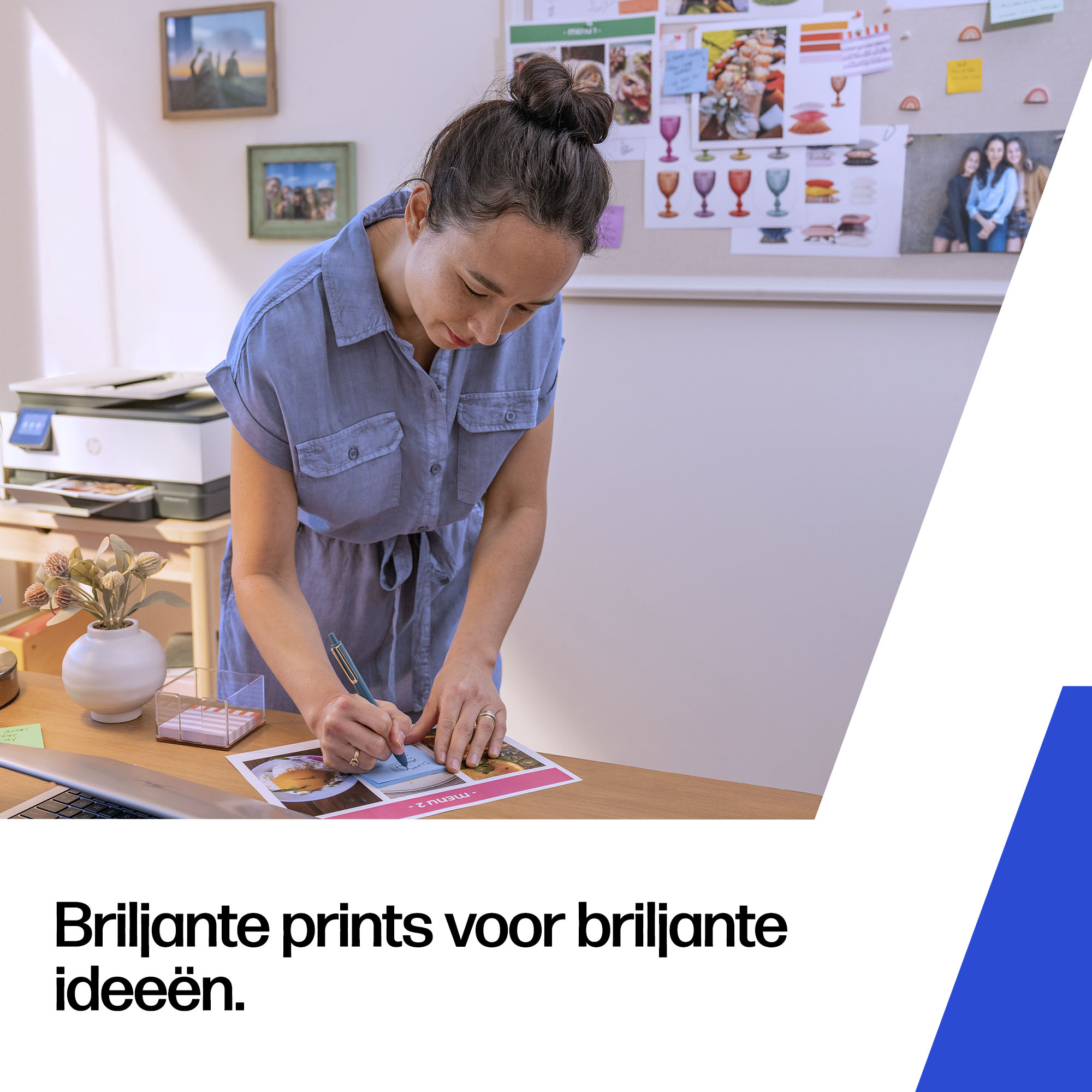 Een vrouw met een knot in een blauwe jurk schrijft op een afdruk.