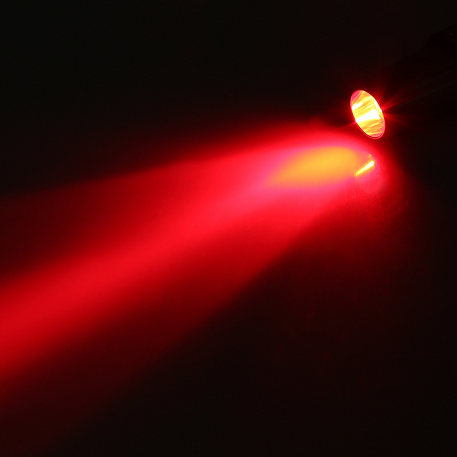 Ein heller roter Lichtstrahl geht von einer Quelle oben rechts aus.