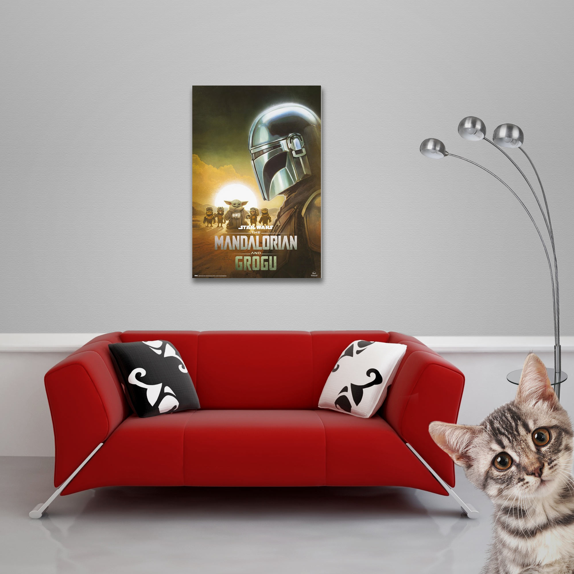 Ein Kätzchen blickt neugierig in die Kamera, neben einem roten Sofa und einem Poster.