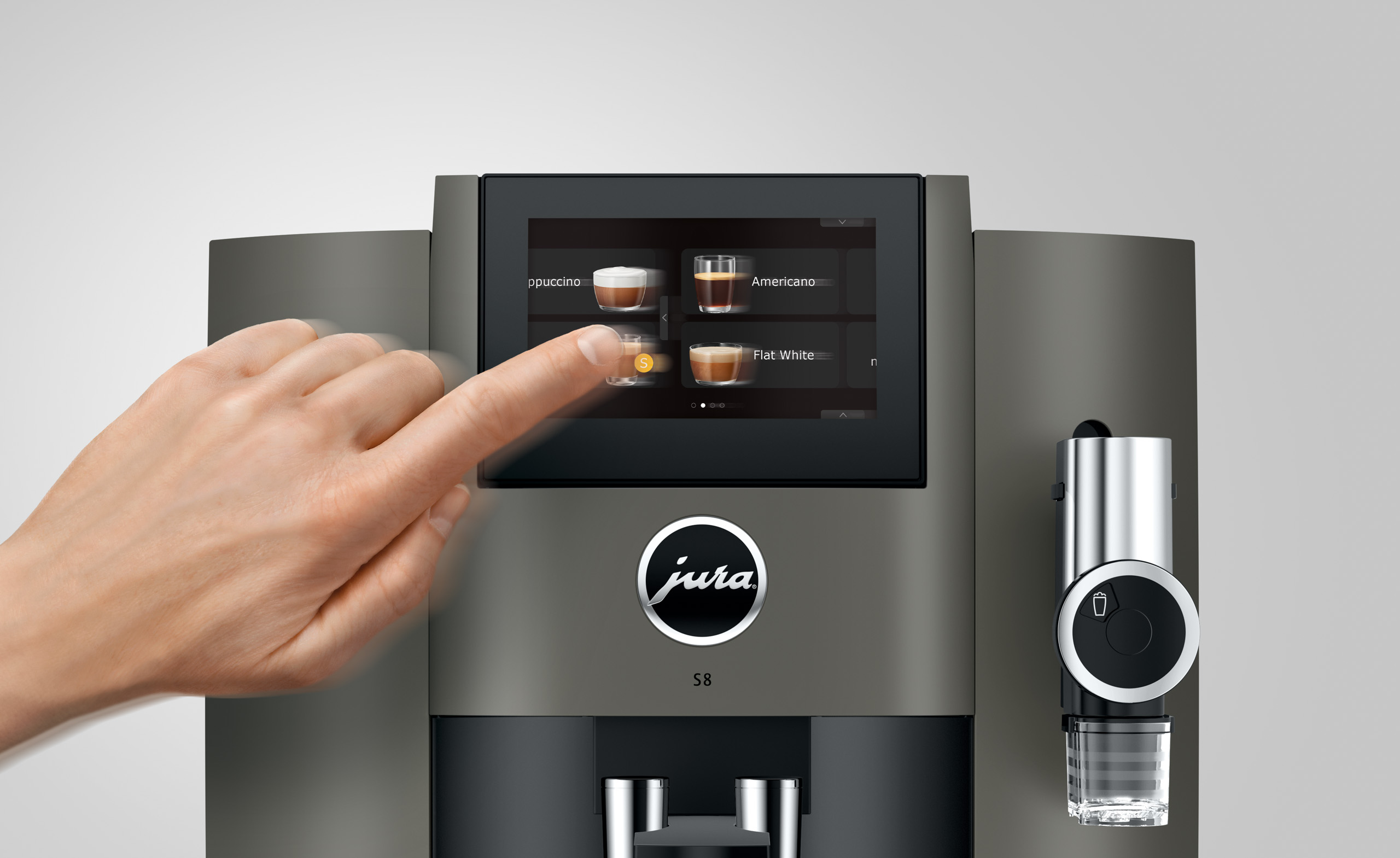 Eine Hand bedient ein Kaffeevollautomaten-Display mit Cappuccino- und Americano-Optionen.